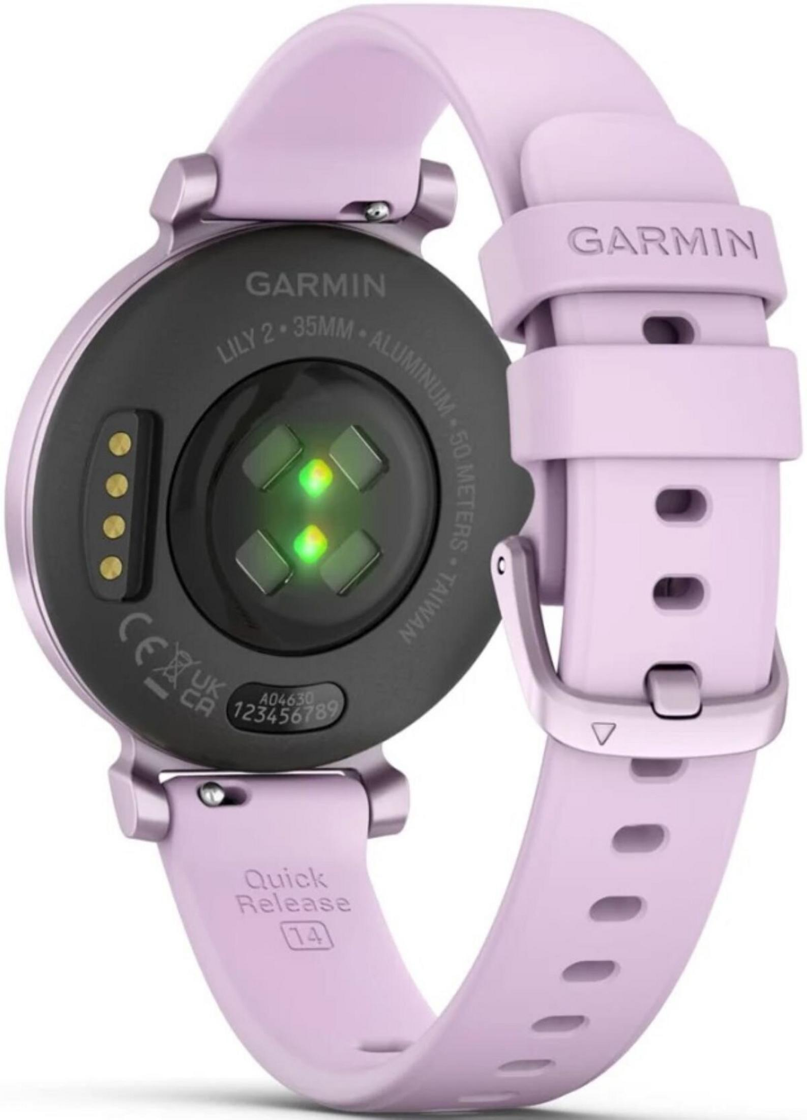Une montre connectée Garmin Lily 2, couleur lilas. Comprend un capteur, un bracelet et le logo Garmin. Le dos affiche des détails techniques.