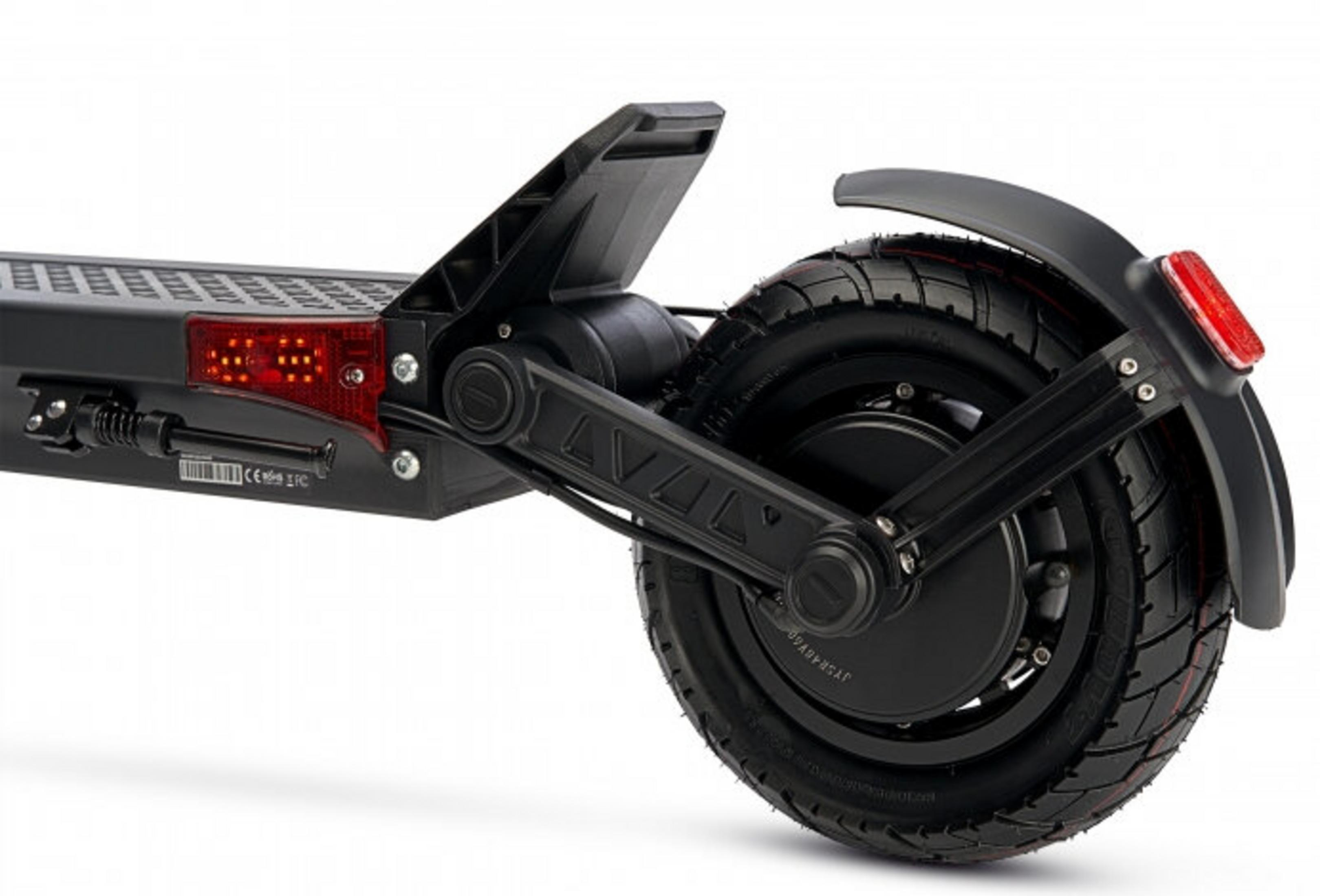 Zbliżenie tylnej części czarnej hulajnogi elektrycznej. Widoczne koło, błotnik, światło stopu i mechanizm składania.