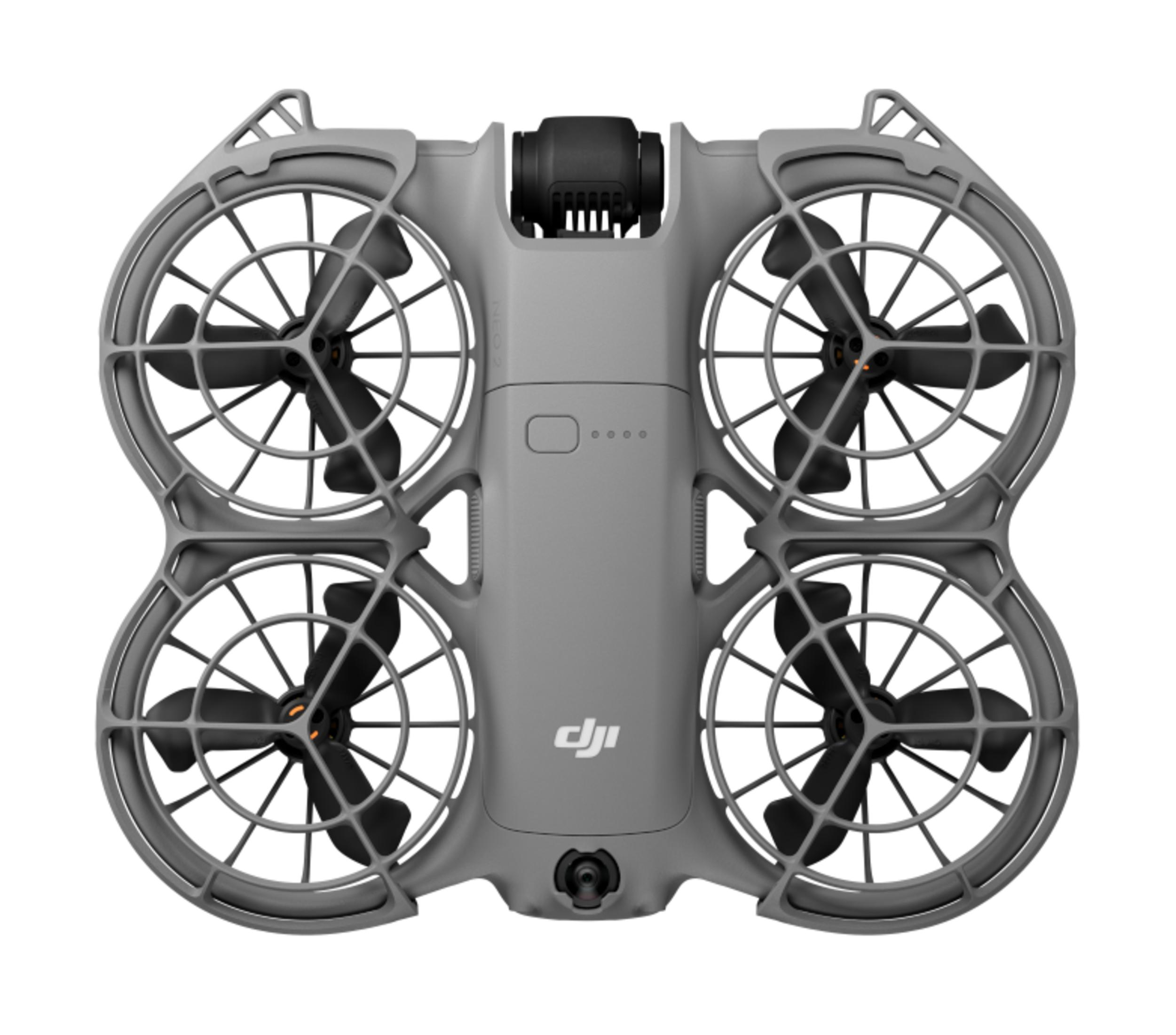 Szary dron z czterema śmigłami, czarnymi łopatkami i centralną kamerą na białym tle.