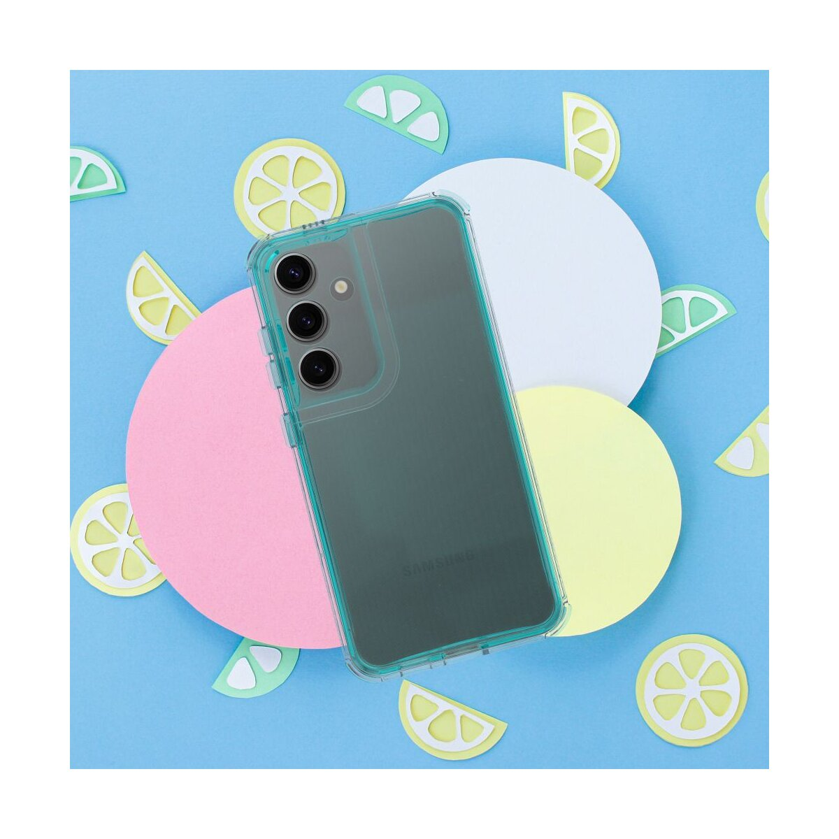 Un telefono in una custodia verde acqua poggia su cerchi colorati e ritagli di limone su sfondo blu, un'allegra composizione.