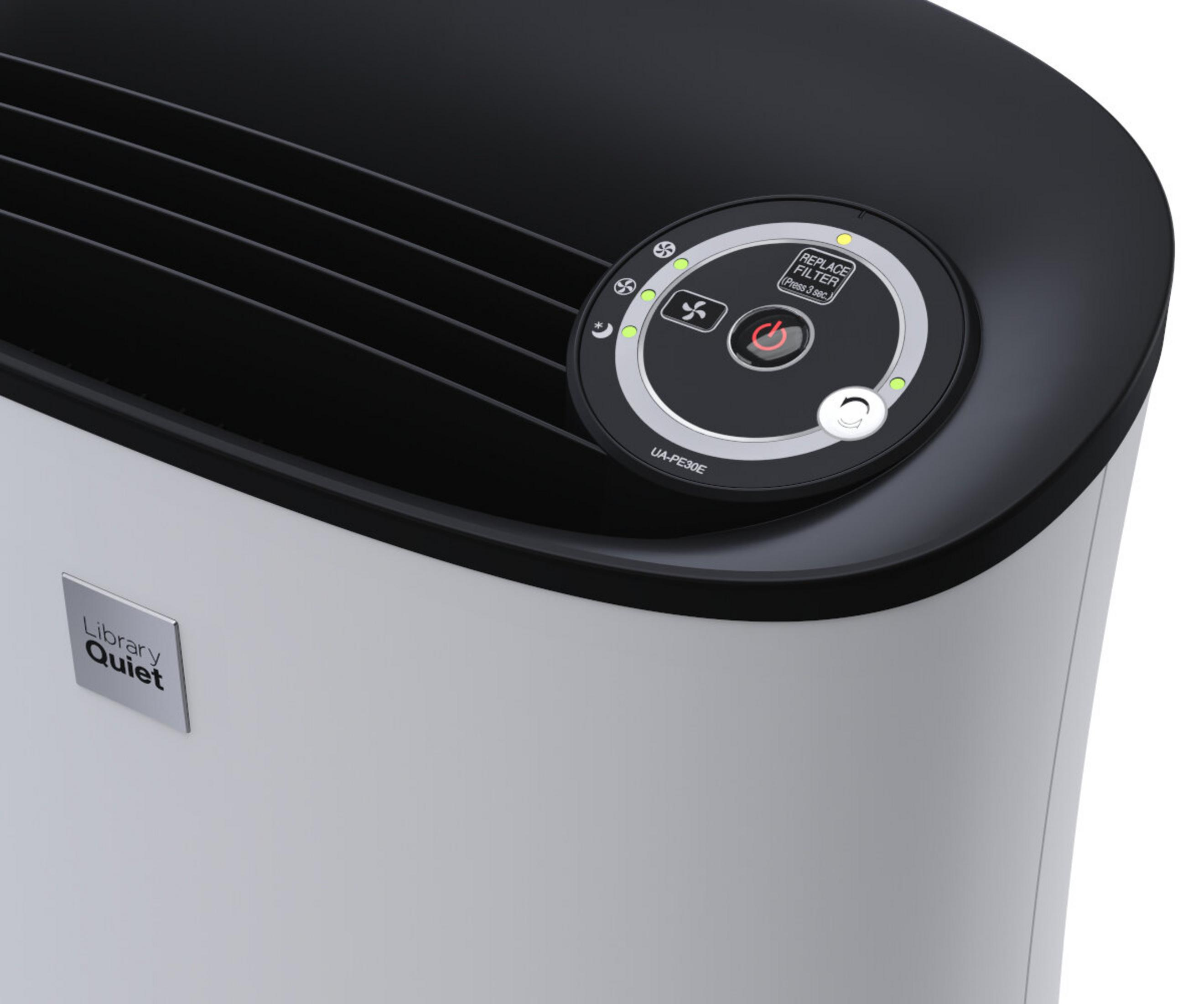 Zbliżenie oczyszczacza powietrza. Posiada panel sterowania z ikonami i przyciskiem zasilania. Urządzenie jest biało-czarne.