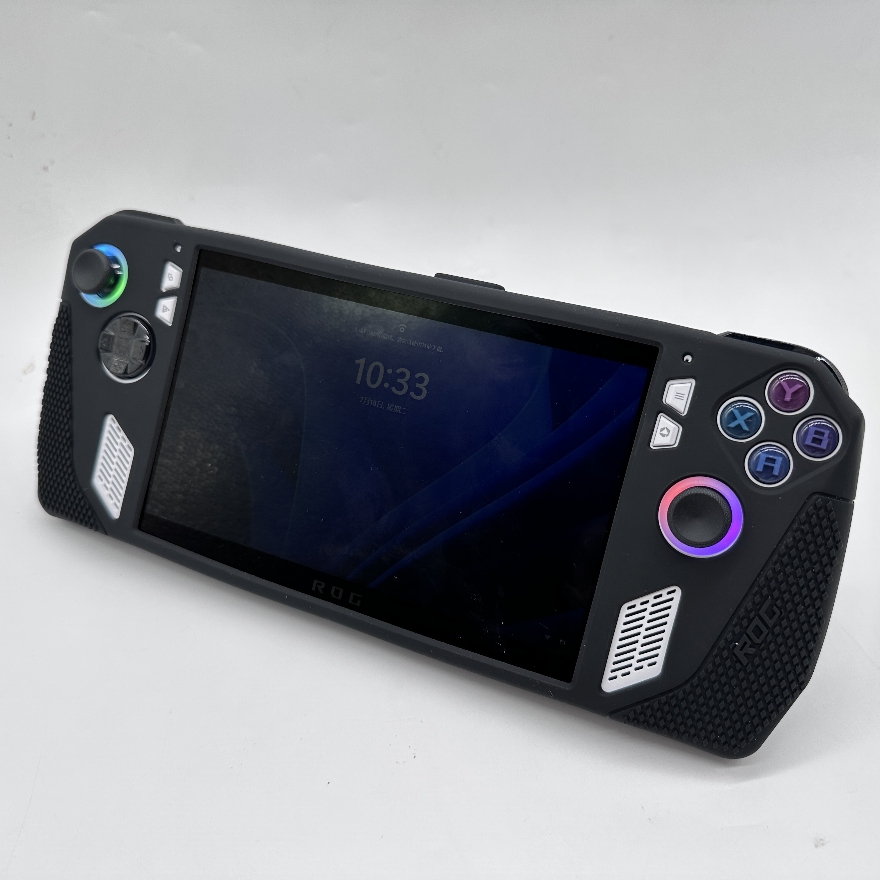 Czarna konsola do gier przenośna z ekranem wyświetlającym godzinę. Posiada przyciski i joystick i znajduje się na białej powierzchni.