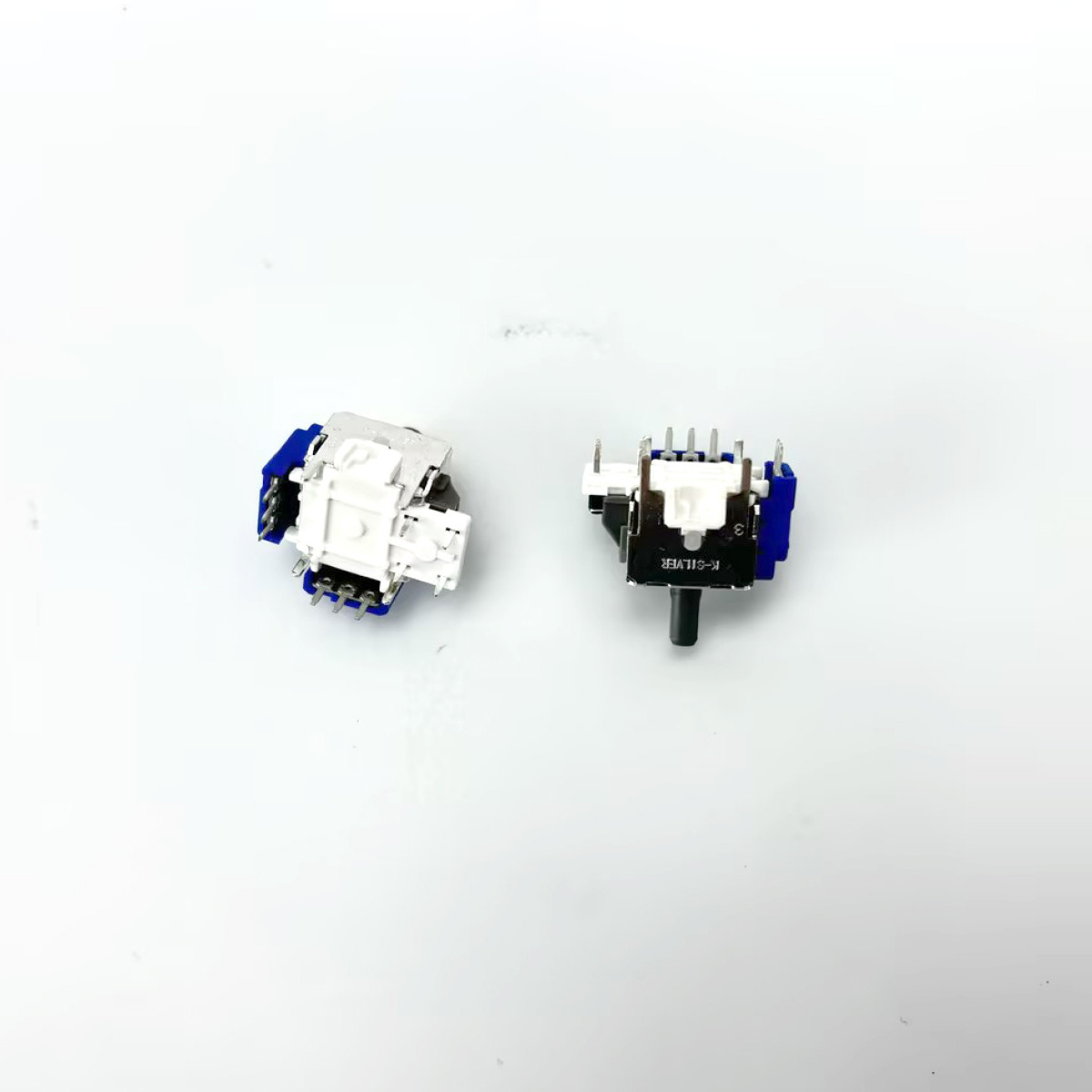 Dwa elementy elektroniczne na białej powierzchni. Jeden jest biało-niebieski, drugi czarno-biało-niebieski.