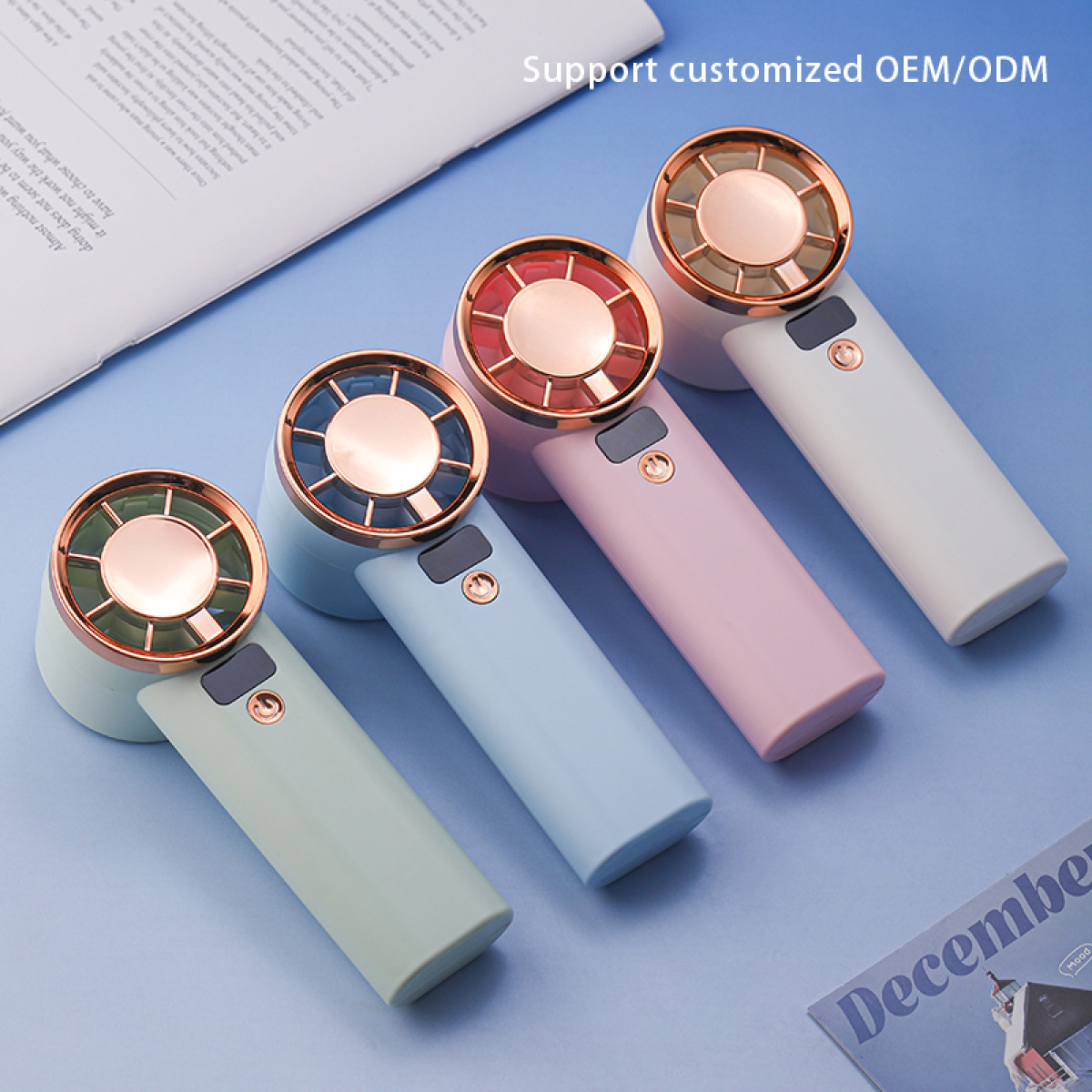 Cztery kolorowe wentylatory ręczne ułożone są po przekątnej na niebieskiej powierzchni. Każdy wentylator ma inny pastelowy uchwyt i dekoracyjny przód.