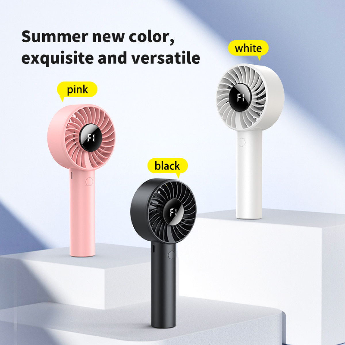 Trzy wentylatory ręczne, różowe, czarne i białe. Każdy ma uchwyt i głowicę wentylatora z wyświetlaczem 'F1'. Tekst brzmi 'Nowy letni kolor'.
