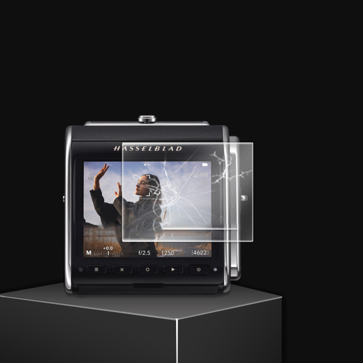 Aparat Hasselblad wyświetla kobietę na ekranie z uszkodzonym ochraniaczem ekranu. Czarne tło, aparat na czarnym stojaku.