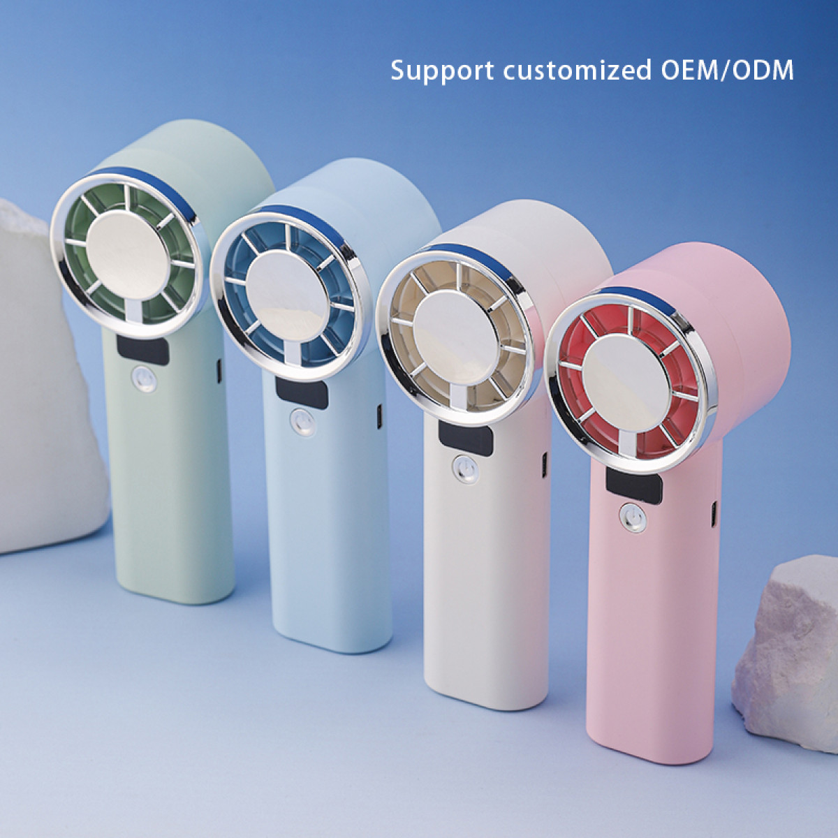 Cztery kolorowe wentylatory ręczne w rzędzie na niebieskim tle, każdy z innym schematem kolorów i srebrnymi akcentami.