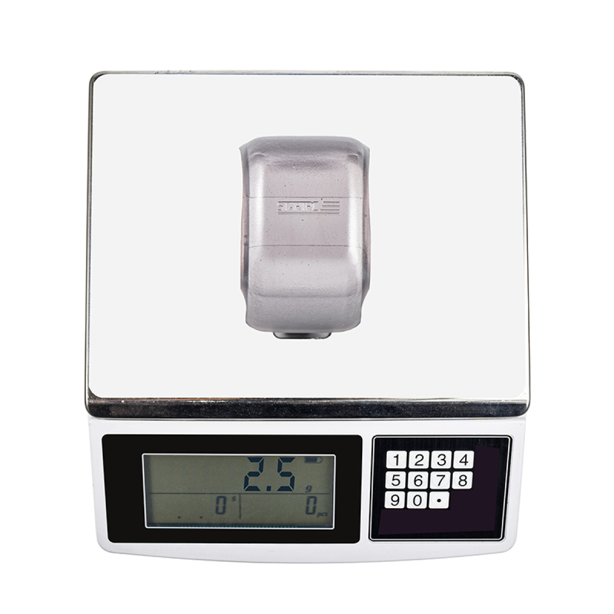 Waga cyfrowa ze srebrnym przedmiotem na platformie. Wyświetlacz pokazuje 2,5 g. Klawiatura numeryczna po prawej.