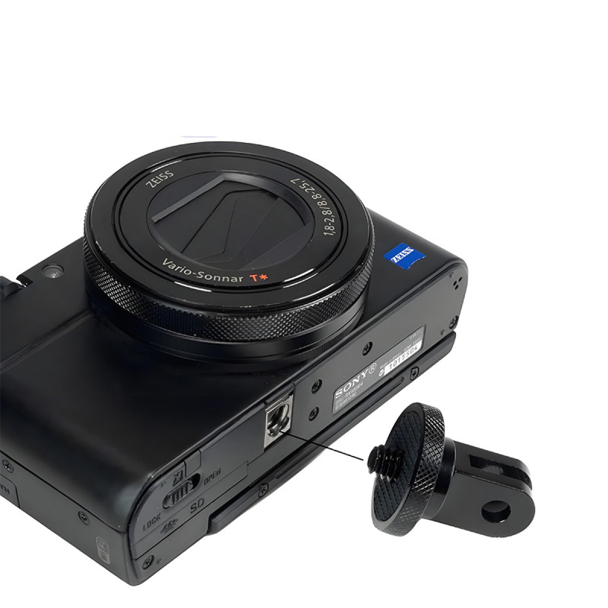 Fotocamera Sony nera con obiettivo Zeiss e supporto treppiede nero staccato. Dettagli della fotocamera visibili.