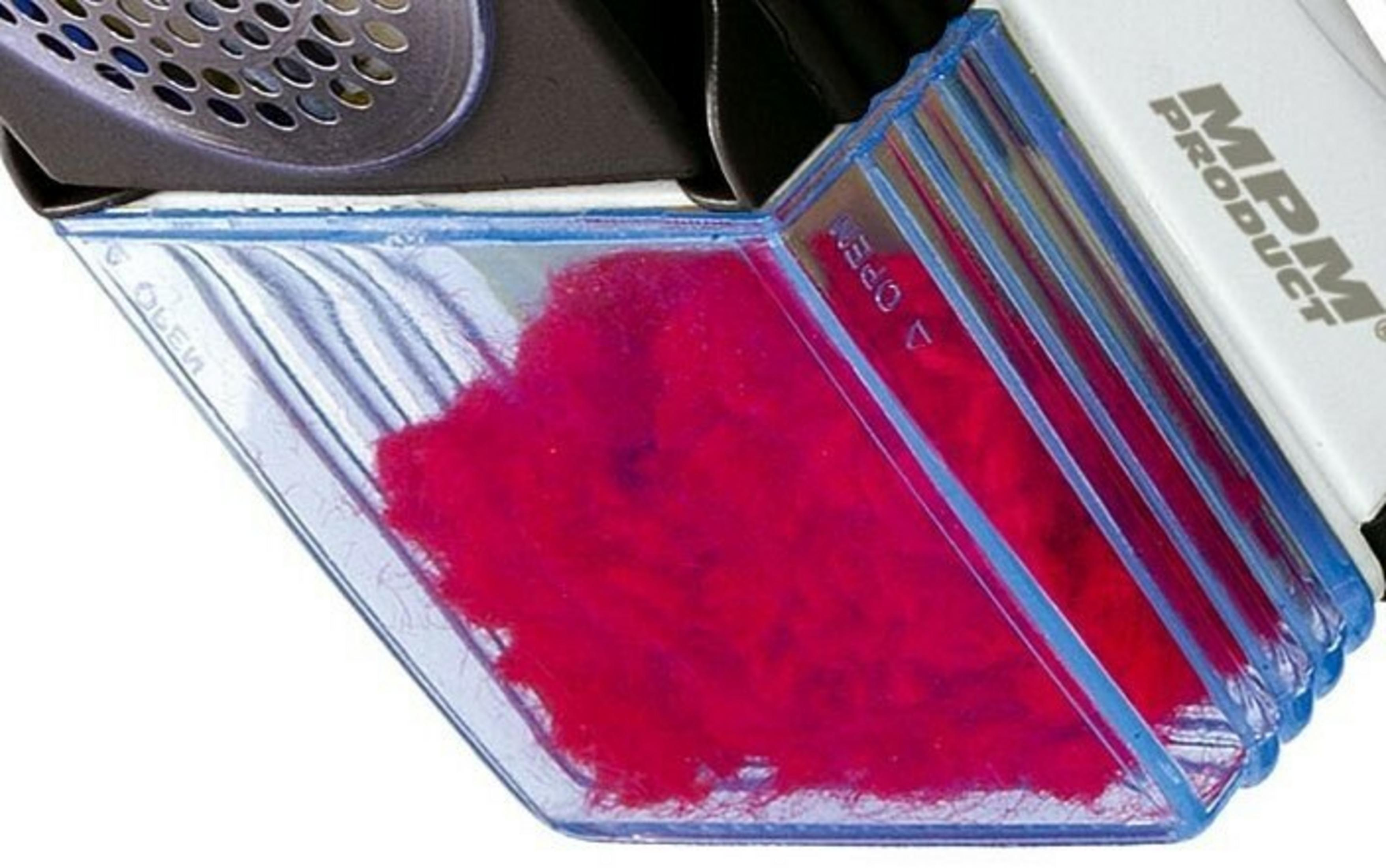 Primo piano del vano trasparente di un levapelucchi pieno di lanugine rossa. Il dispositivo ha un design in bianco e nero.