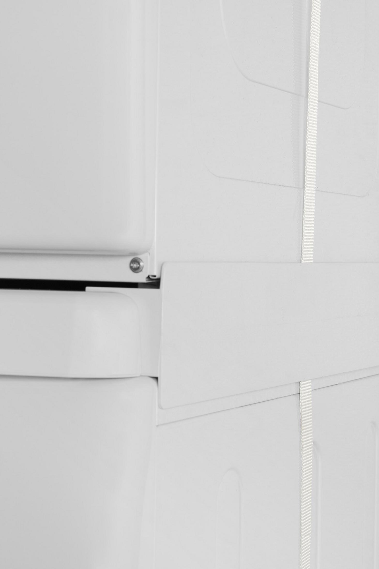 Close-up van witte panelen met een witte band. Panelen zijn verbonden en hebben lichte rondingen. Een schroef is zichtbaar.