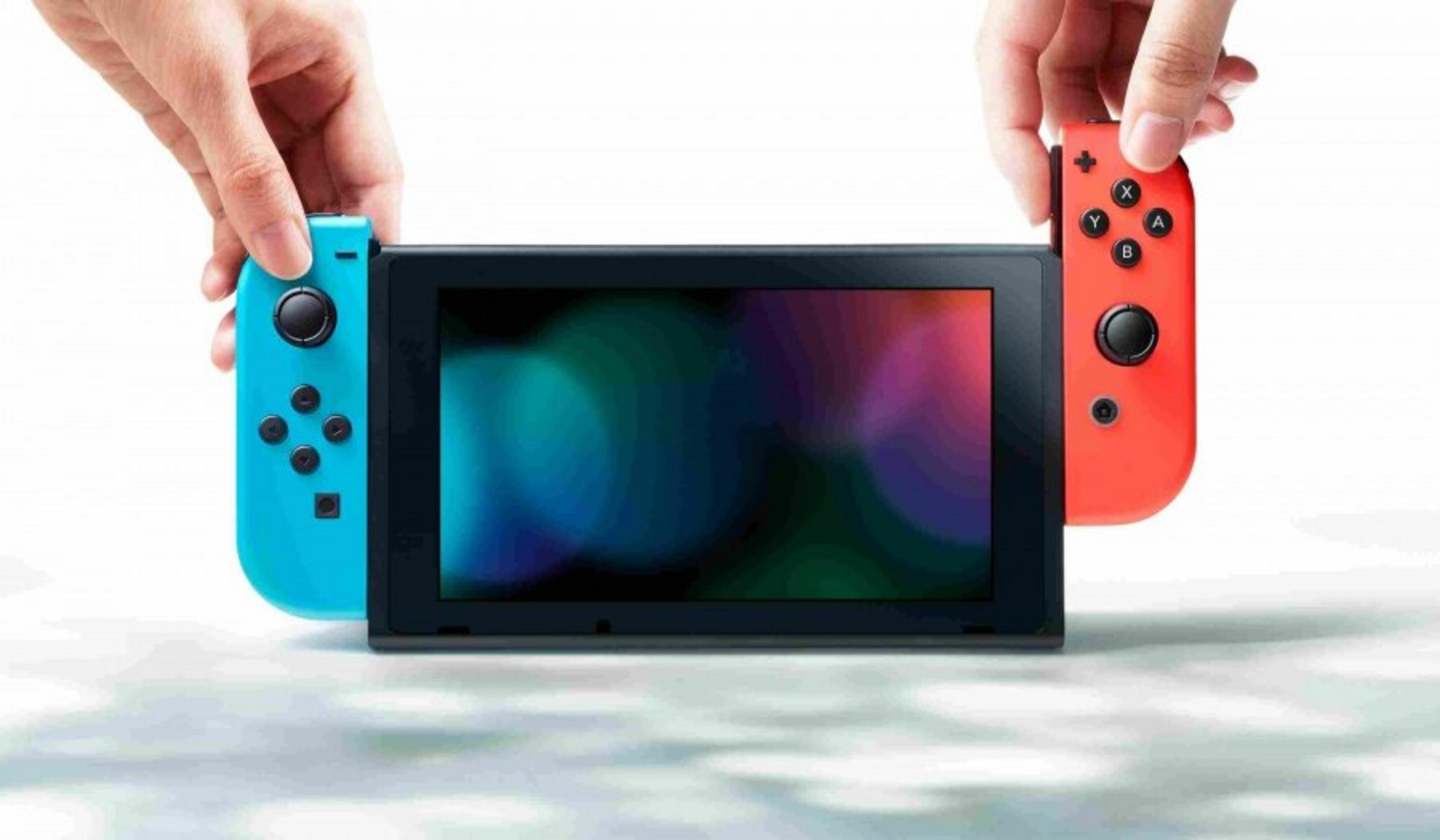 Hände halten eine Nintendo Switch mit abgenommenen Controllern. Die Controller sind blau und rot. Der Bildschirm zeigt bunte Formen.