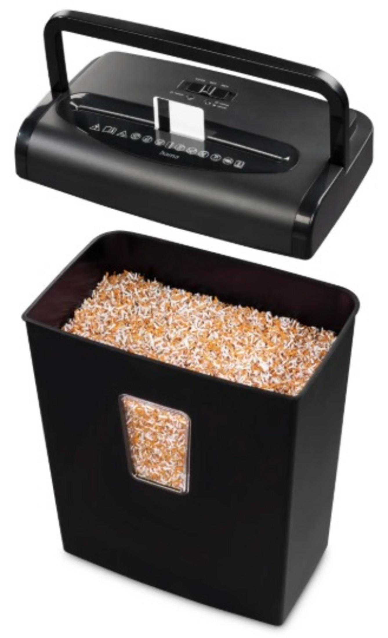 Czarna niszczarka do papieru, górna część z uchwytem, ​​znajduje się nad pojemnikiem wypełnionym pociętym papierem. Pojemnik ma okno.