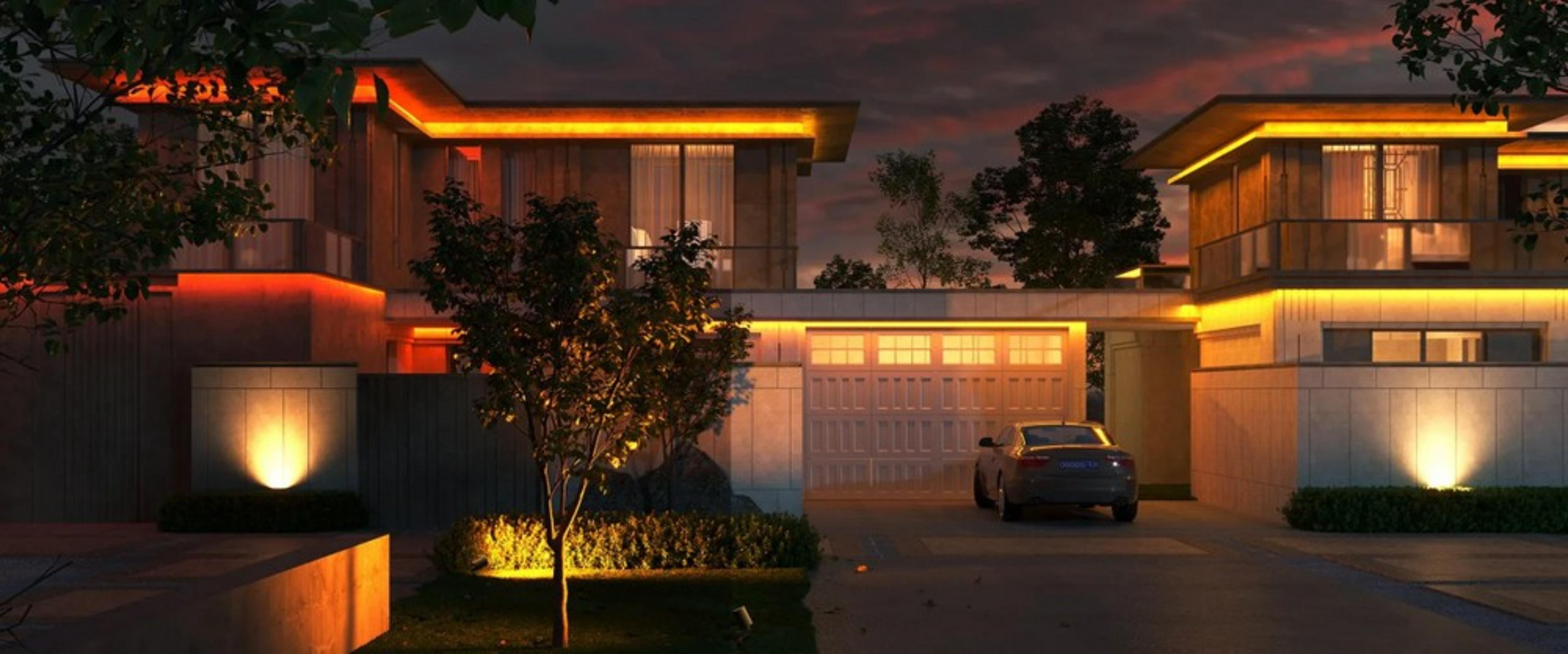Nowoczesny dom o zmierzchu, oświetlony ciepłymi światłami. Samochód zaparkowany na podjeździe.