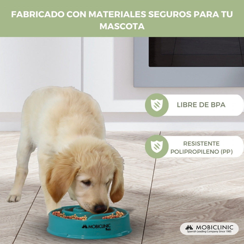 Un cachorro golden retriever come de un cuenco alimentador lento color turquesa. El texto superior dice: Hecho con materiales seguros para tu mascota.