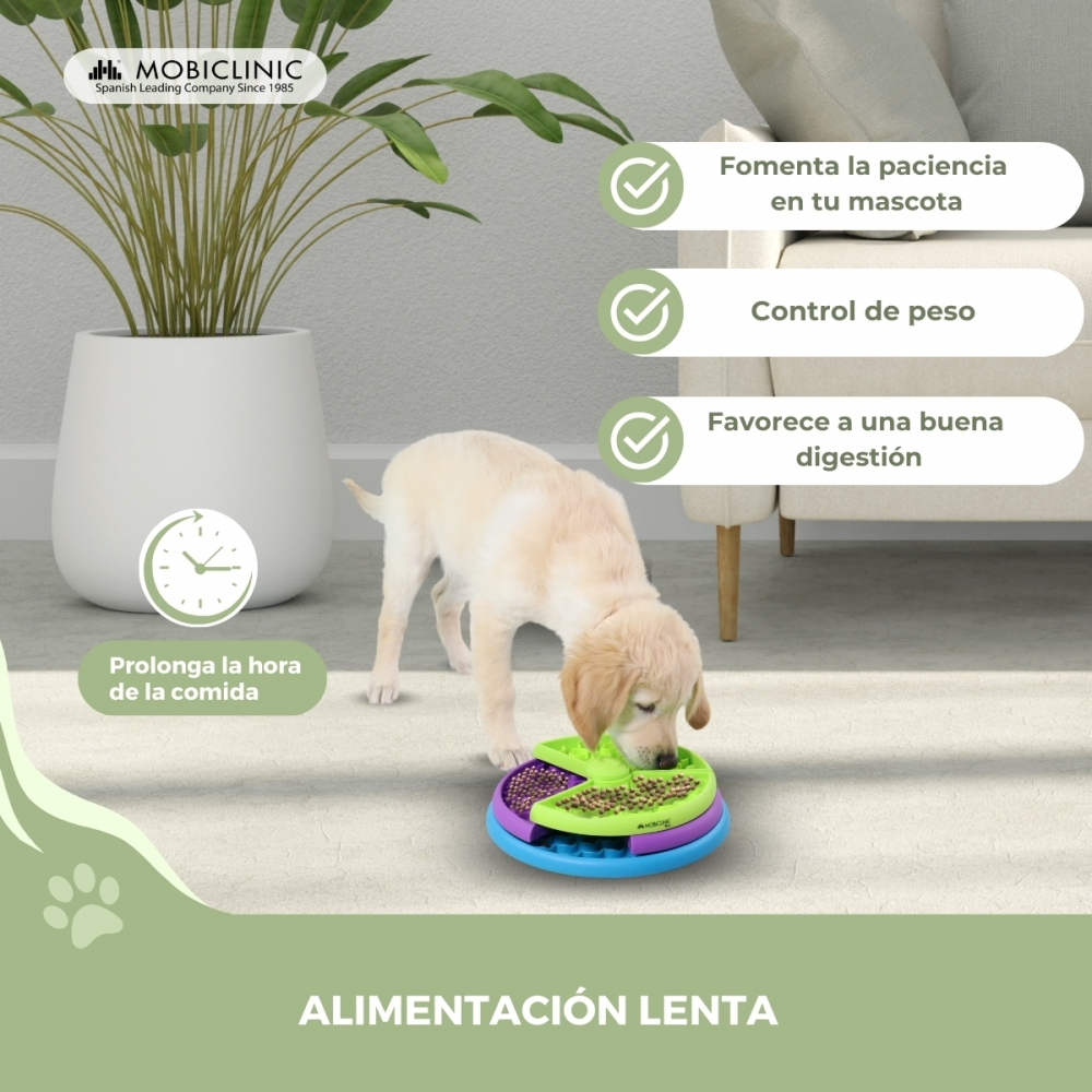 Un cachorro come de un comedero lento. El texto destaca beneficios: paciencia, control de peso, digestión. Planta y sofá de fondo.
