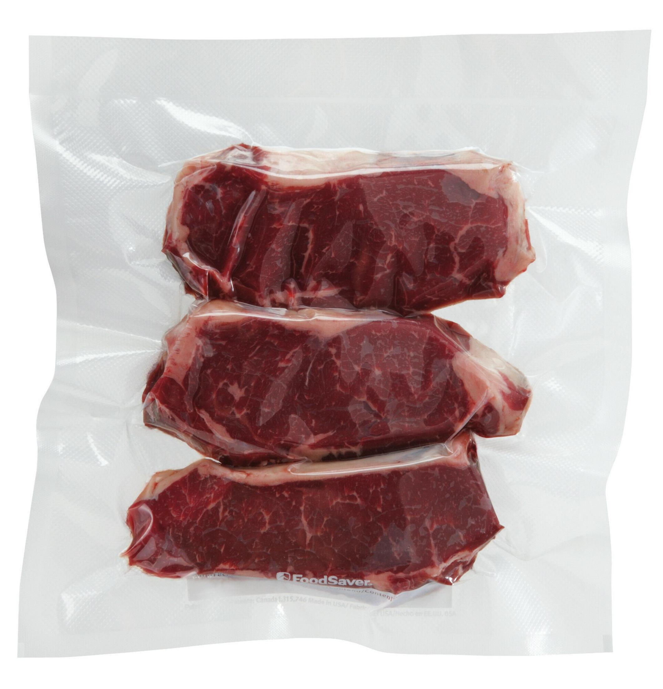 Drei rohe Steaks, vakuumverpackt in einer transparenten Plastiktüte. Die Steaks sind rot mit weißer Fettmarmorierung.