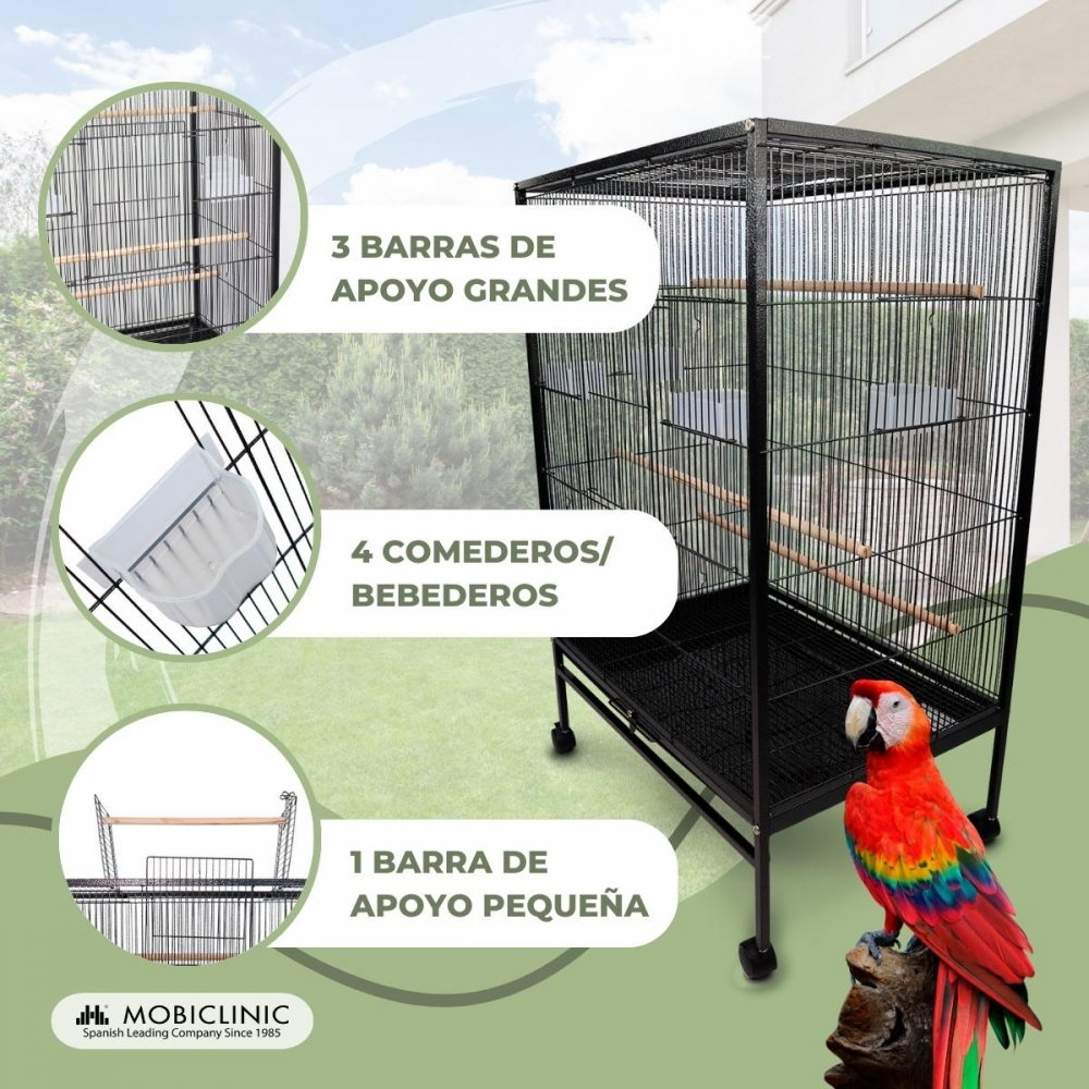 Una jaula grande y negra con un guacamayo posado en una base de madera. La jaula tiene barras, perchas y comederos/bebederos.