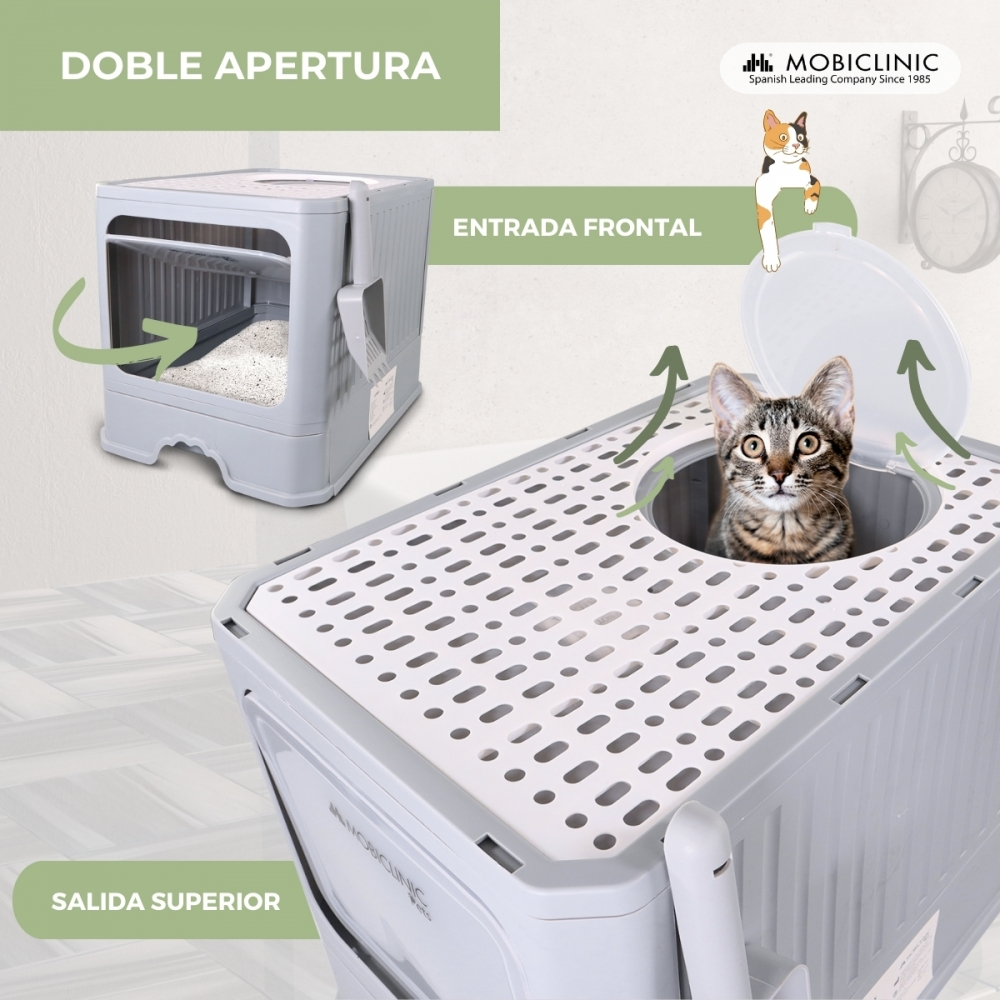 Un gato dentro de una caja de arena gris. La caja tiene una entrada superior y una puerta frontal. El texto indica 'Doble apertura' y 'Entrada frontal'.