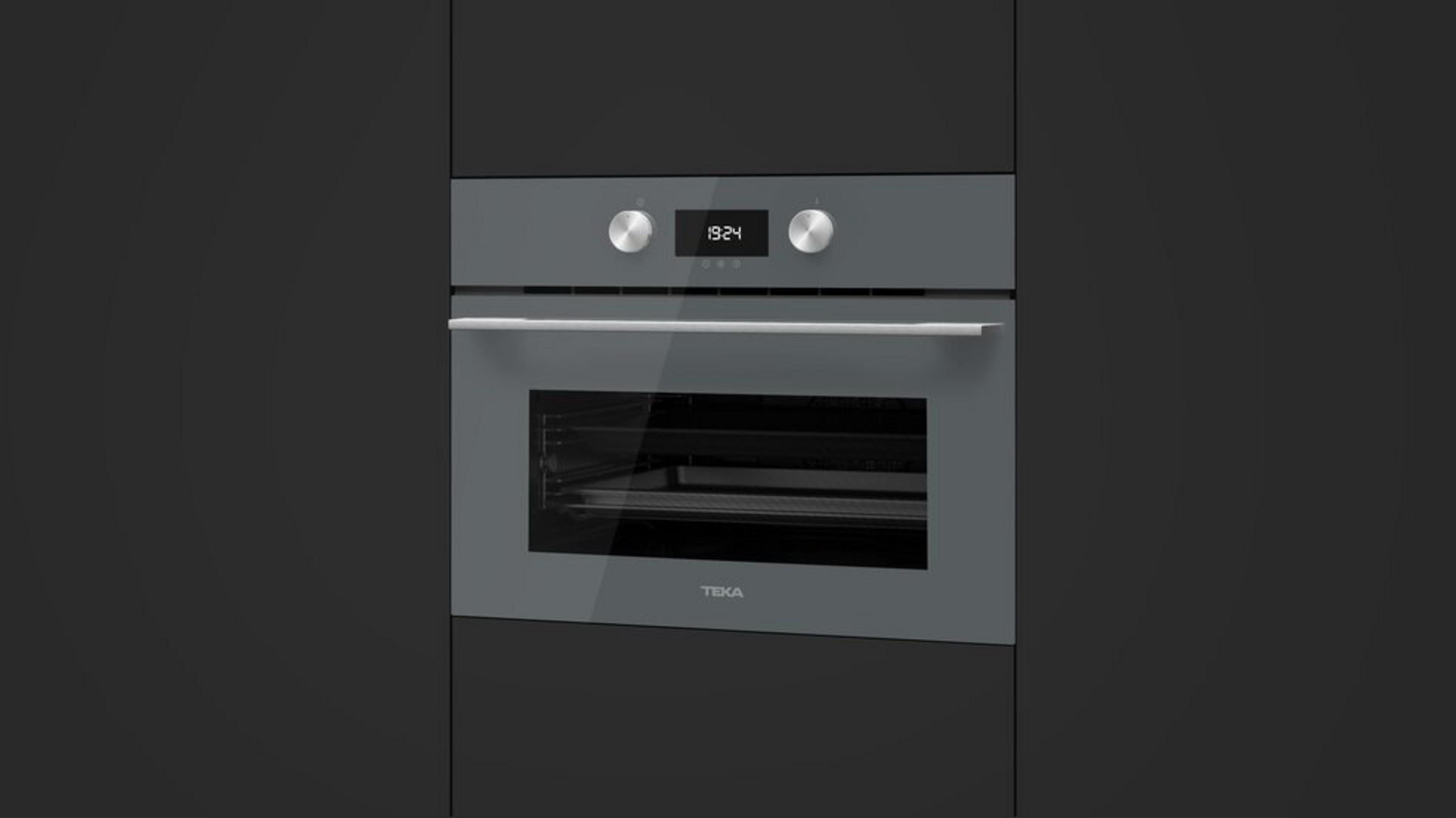Un horno gris con puerta de cristal, reloj digital (19:24) y dos perillas. Está en un armario gris oscuro.