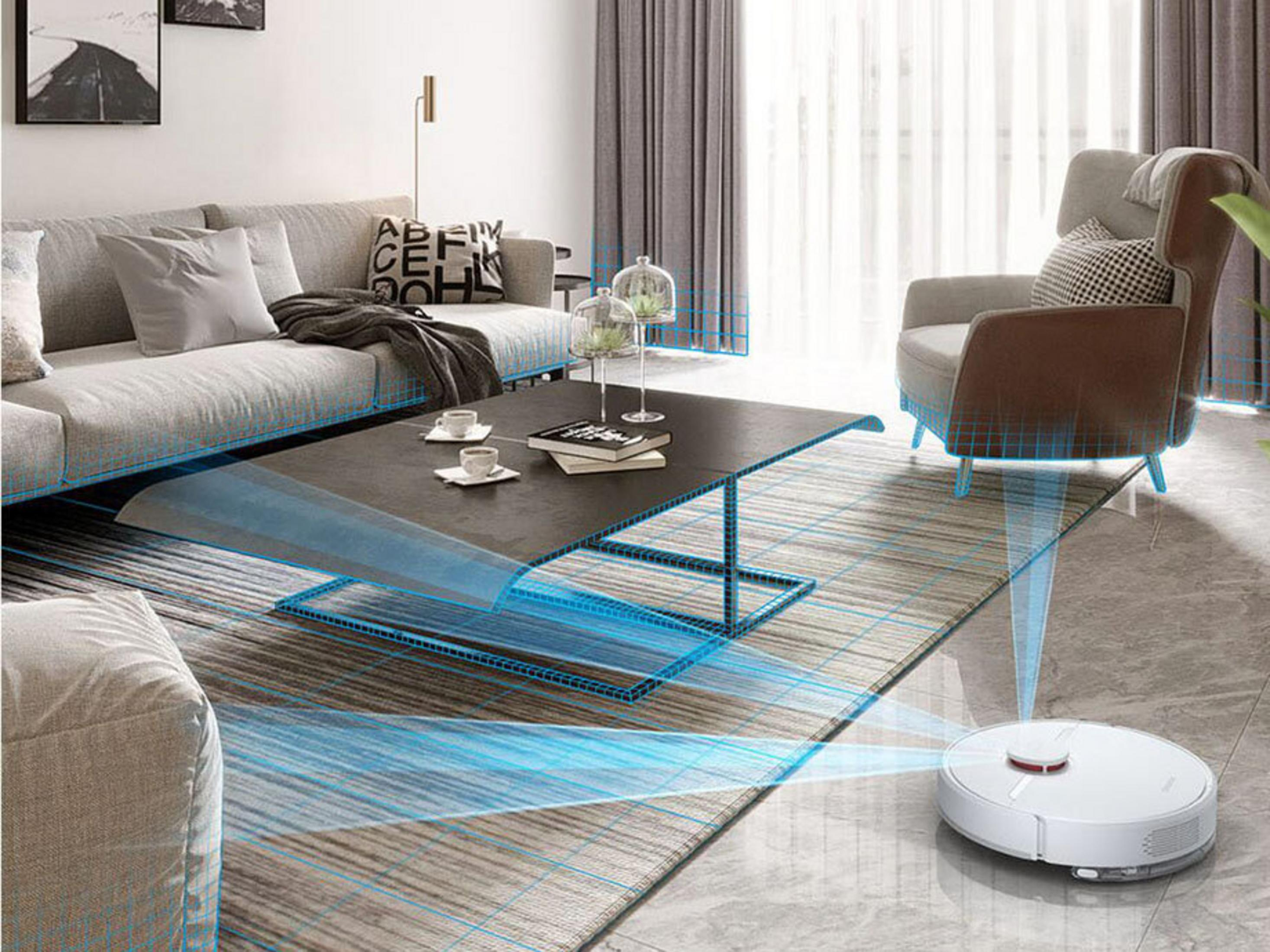 Un aspirapolvere robot bianco sul pavimento, vicino a un tappeto, che pulisce il soggiorno.