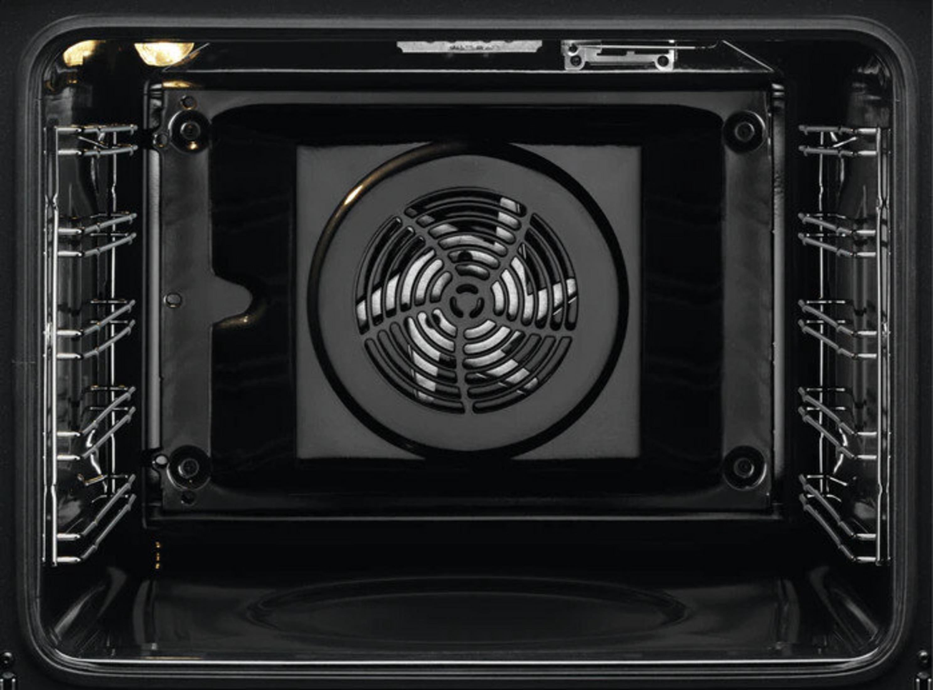Vista interior de un horno negro. Un ventilador está en el centro. Las rejillas están a los lados.