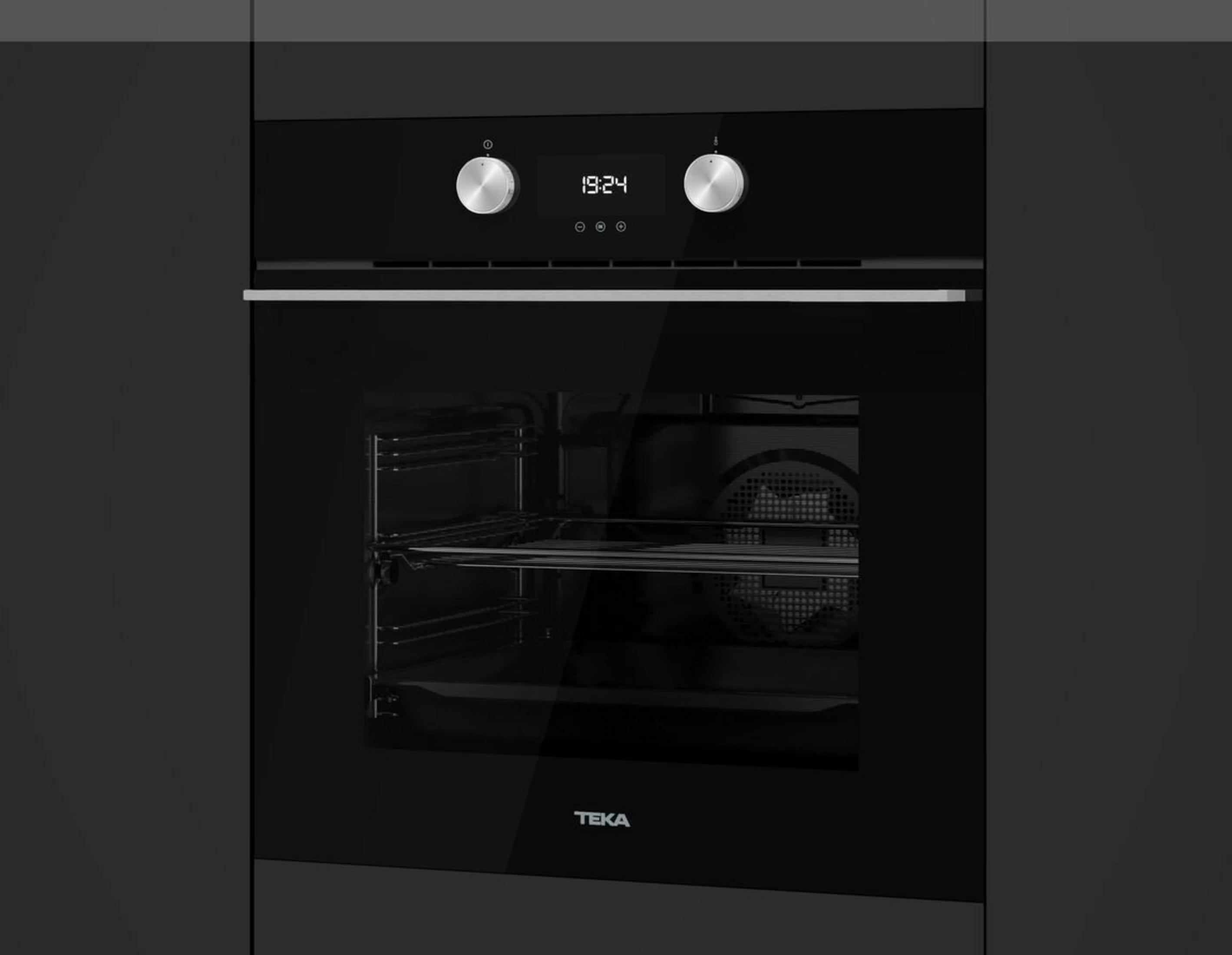 Czarny piekarnik z wyświetlaczem 19:24. Ma stalowe pokrętła i szklane drzwi z logo TEKA.