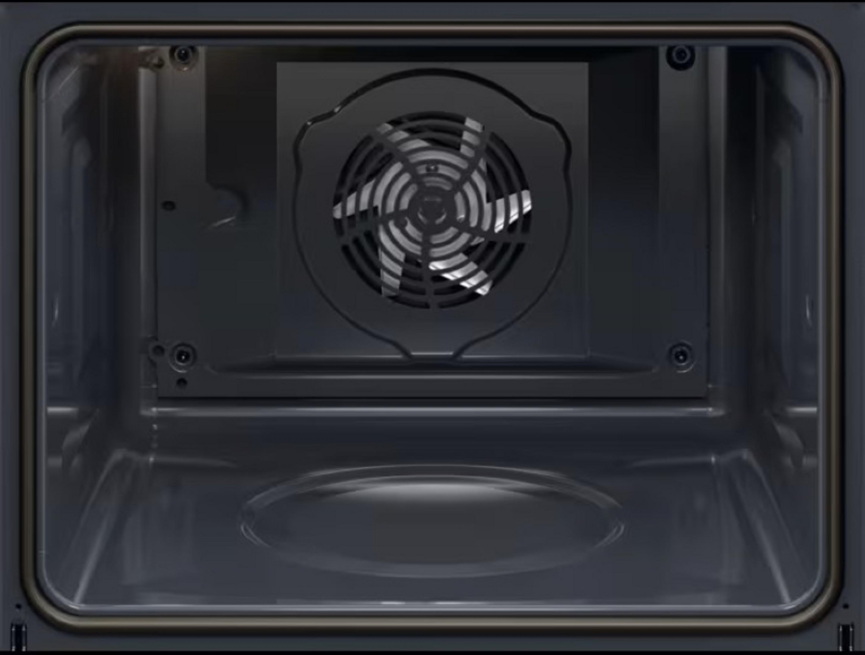 Wnętrze ciemnego piekarnika. Z tyłu widoczny jest wentylator, a ściany piekarnika są ciemne.