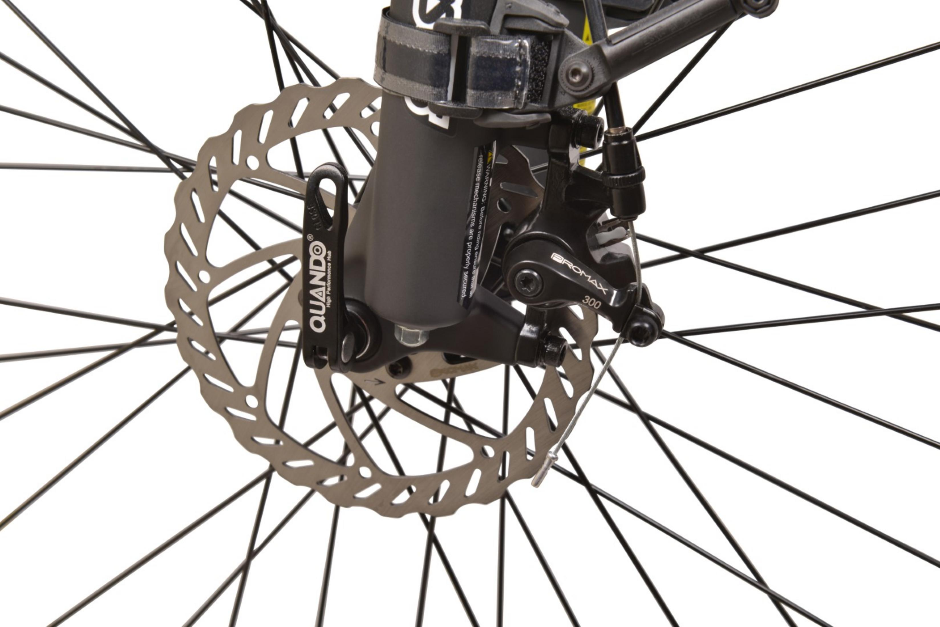 Zbliżenie hamulca tarczowego i koła roweru. Hamulec ma srebrny rotor, czarny zacisk, a koło czarne szprychy.