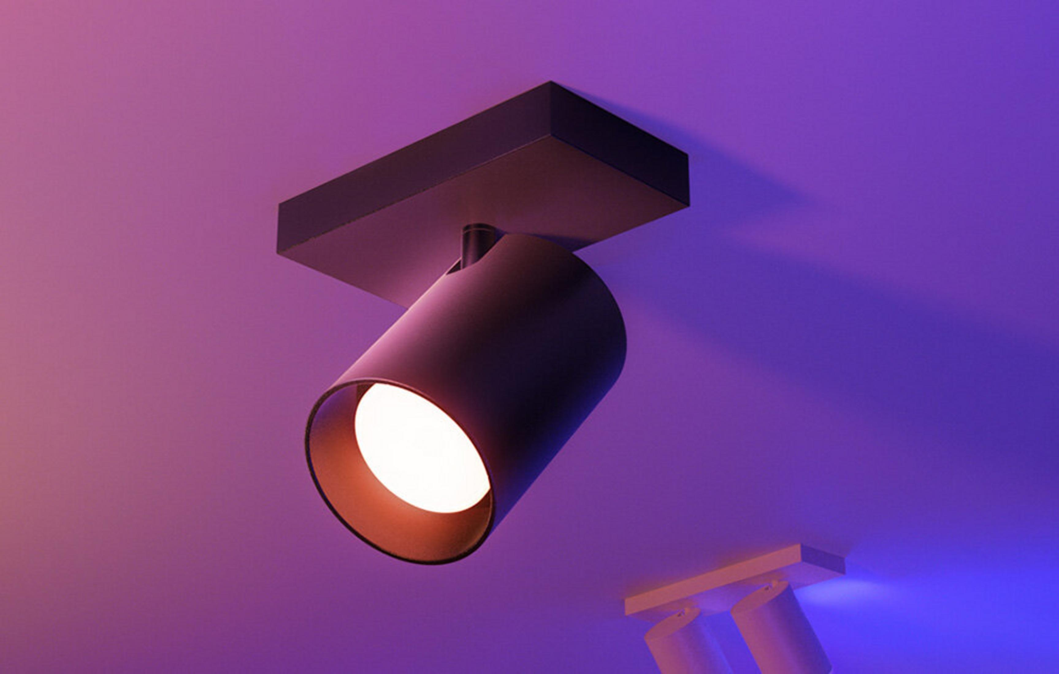 Nowoczesny reflektor na fioletowym suficie. Światło świeci jasno.