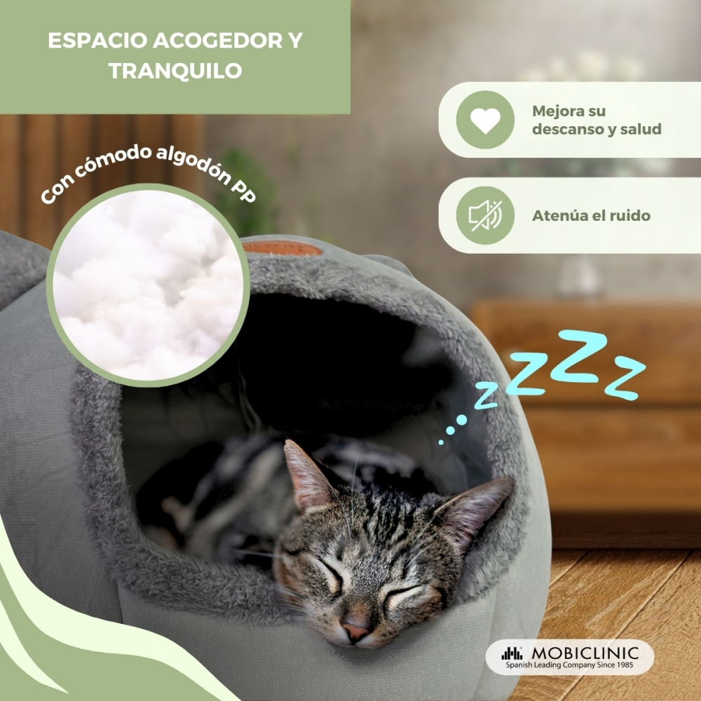 Un gato duerme plácidamente dentro de una cama gris para mascotas. La cama tiene algodón suave. El texto menciona espacio acogedor y beneficios.