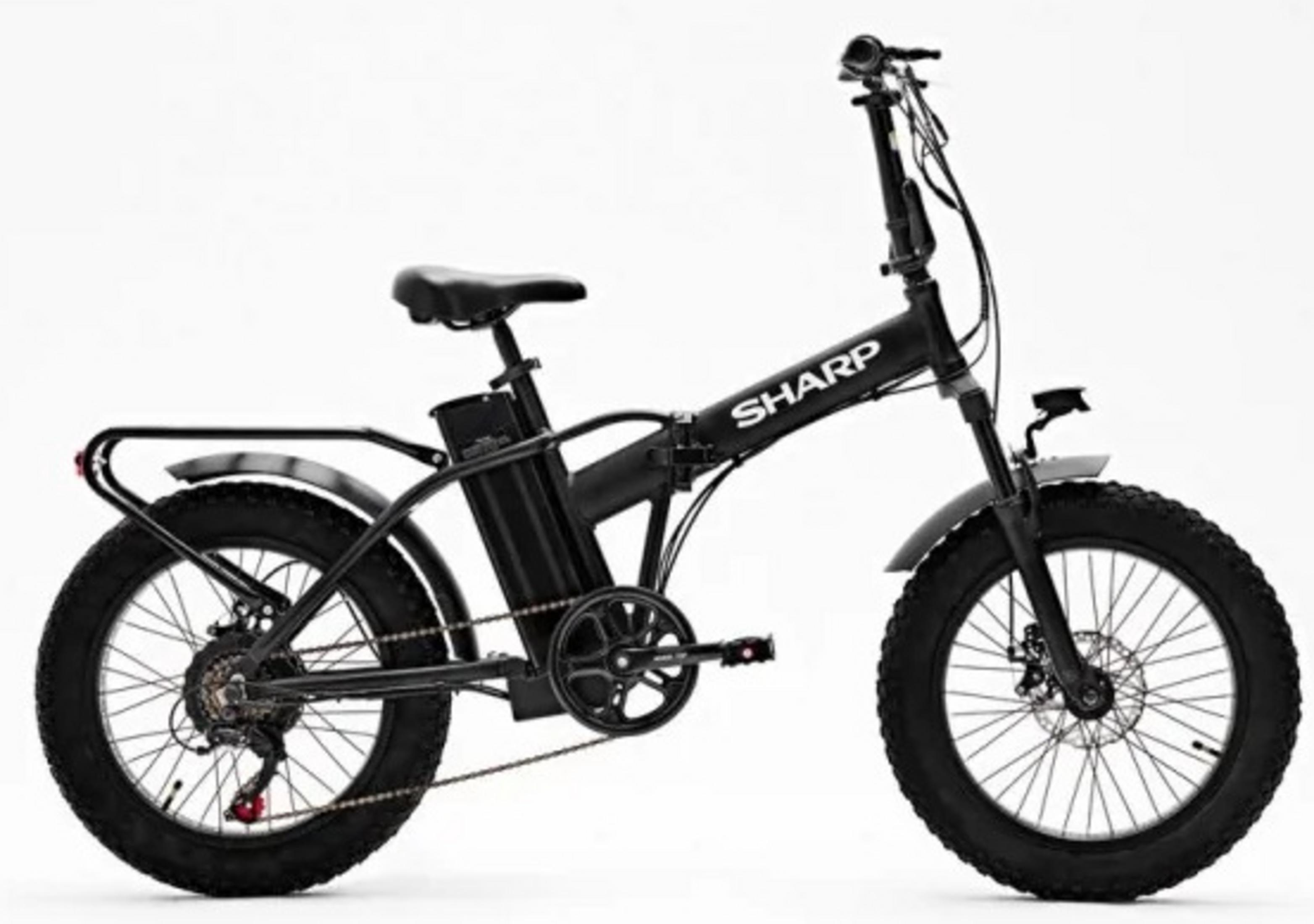 Una bici elettrica SHARP nera con pneumatici grandi su sfondo bianco. Ha un portapacchi e una batteria.