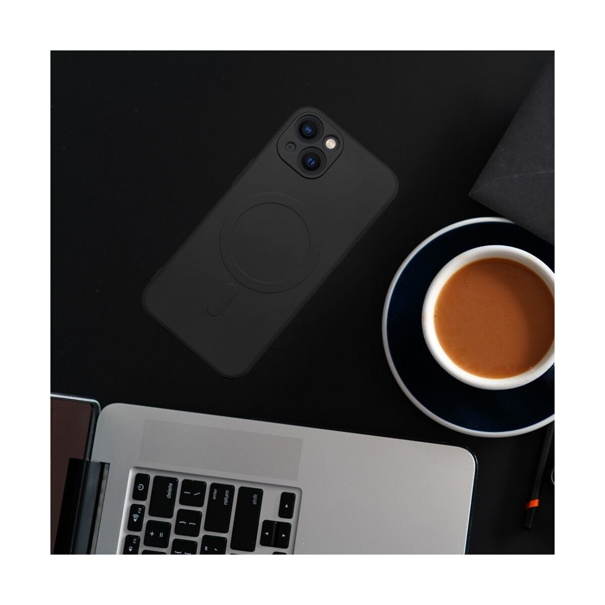 Schwarzes iPhone mit Hülle, Kaffeetasse, Laptop und Stift auf schwarzer Oberfläche. Ein dunkler Umschlag.