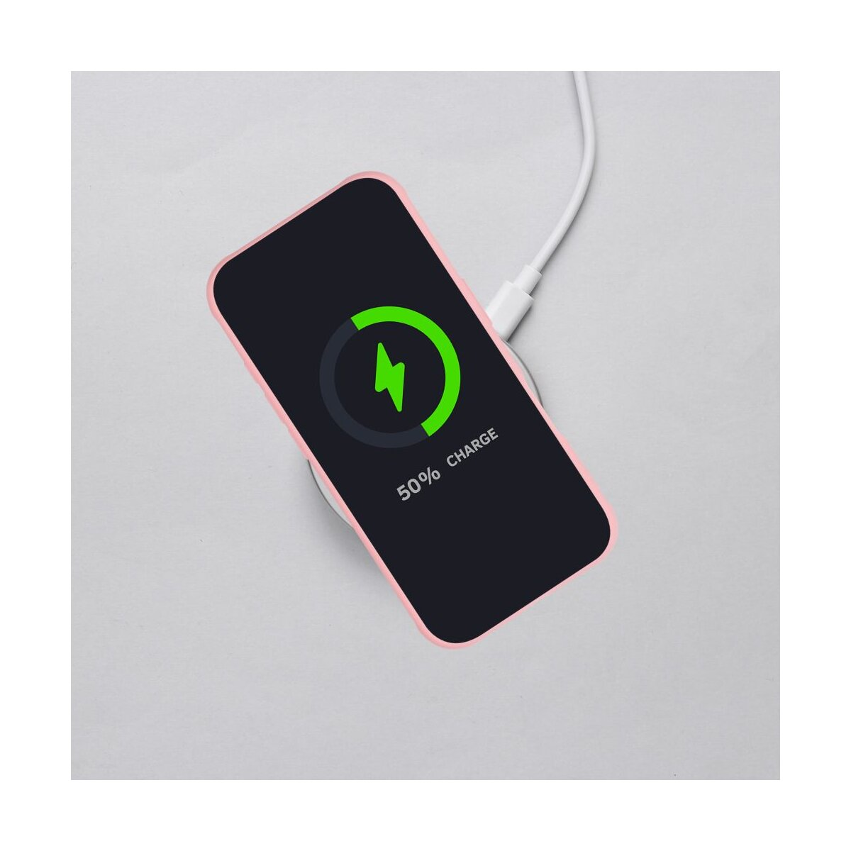 Ein Telefon, das drahtlos auf einem weißen Pad geladen wird. Der Bildschirm zeigt ein grünes Ladesymbol bei 50 % Ladung.
