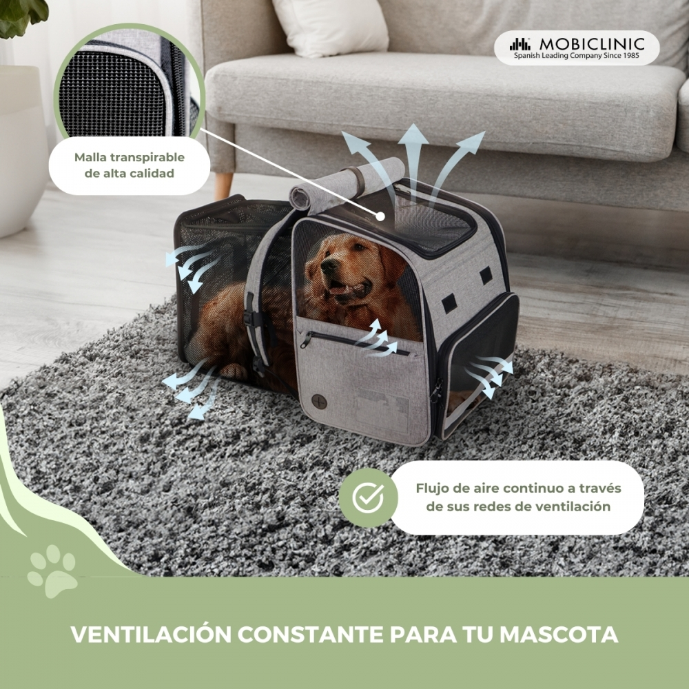 Un perro en un transportín gris. Las flechas muestran el flujo de aire. El texto dice "ventilación constante para tu mascota". Malla transpirable.