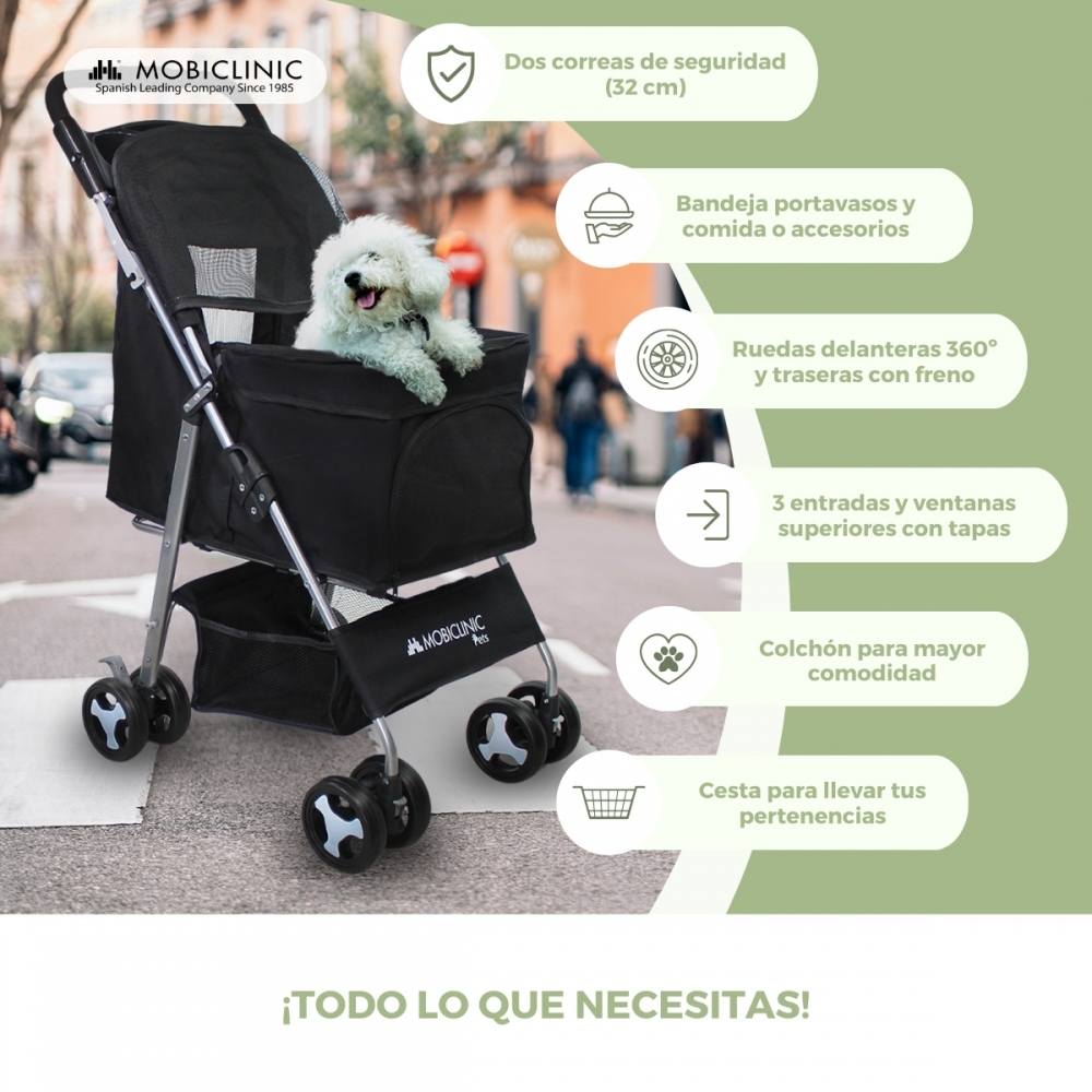 Un cochecito negro para mascotas con un perro blanco dentro. Incluye correas de seguridad, portavasos, ruedas 360° y cesta.