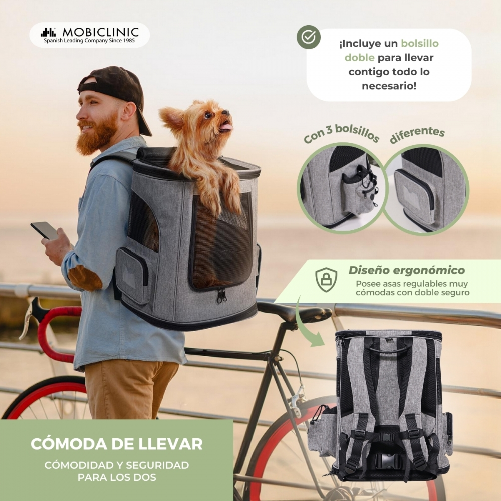 Un hombre con un perro en una mochila en una bicicleta. La mochila es gris. El perro es marrón.