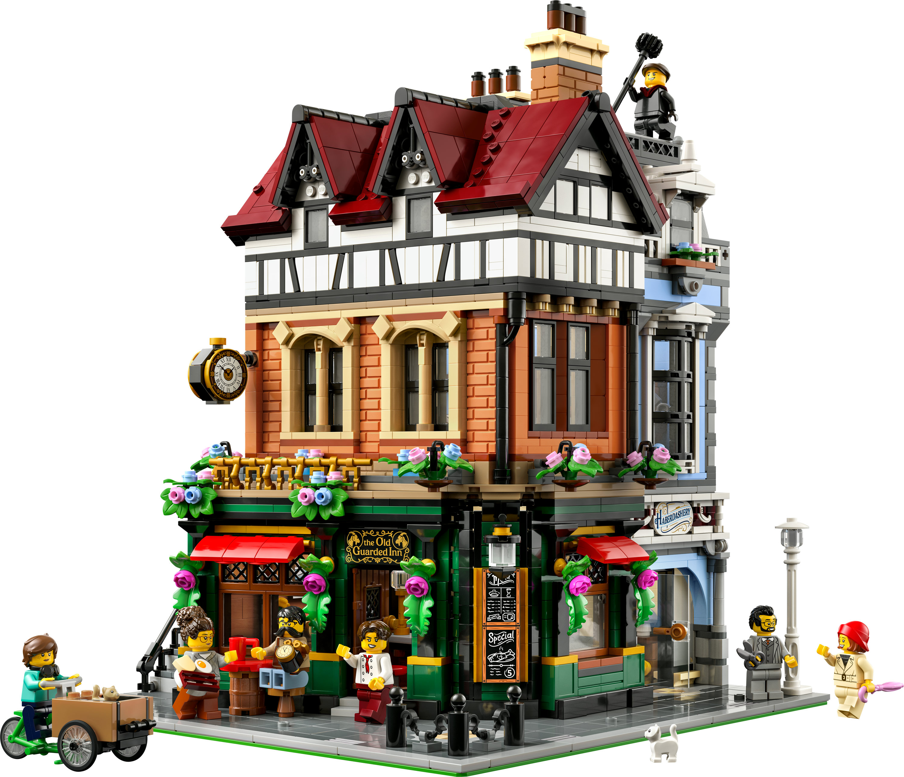 Lego-Modell eines Pubs. Figuren stehen davor, ein Schornsteinfeger auf dem Dach. Der Pub hat rote Dächer und schwarz-weiße Wände.