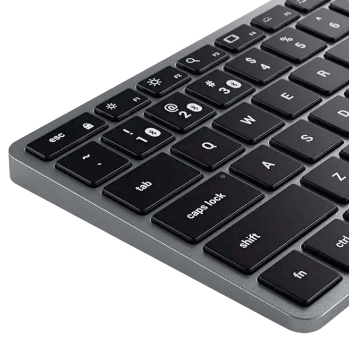 Nahaufnahme einer silbernen Tastatur mit schwarzen Tasten. Tasten umfassen Buchstaben, Zahlen und Symbole. 'Shift'- und 'Feststelltaste' sind sichtbar.
