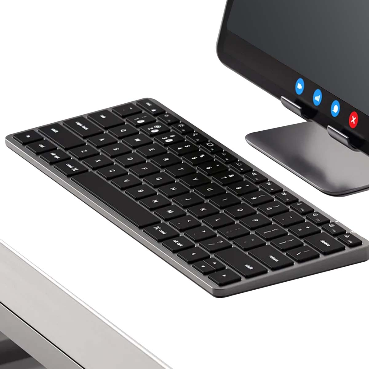 Nahaufnahme einer schwarzen Tastatur mit grauen Kanten und einem Tablet im Hintergrund. Die Tastatur ist zentriert, Tasten sind sichtbar.