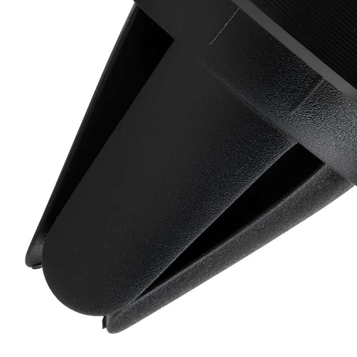 Primo piano di un oggetto di plastica nera, forse una presa d'aria per auto. Forme angolari e texture visibili su sfondo bianco.