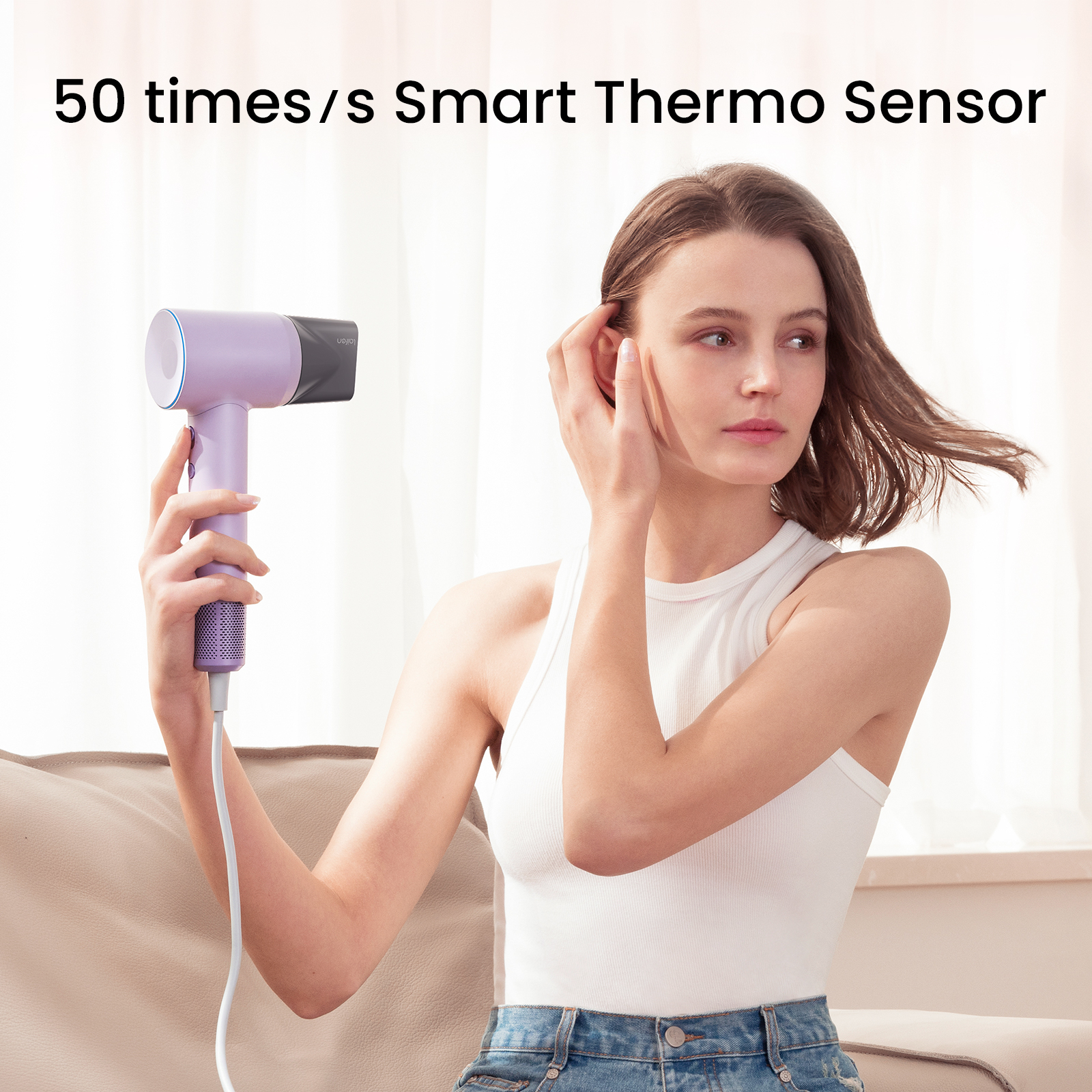 Une femme tenant un sèche-cheveux violet, touchant ses cheveux. Texte en haut : 50 fois/s Smart Thermo Sensor.