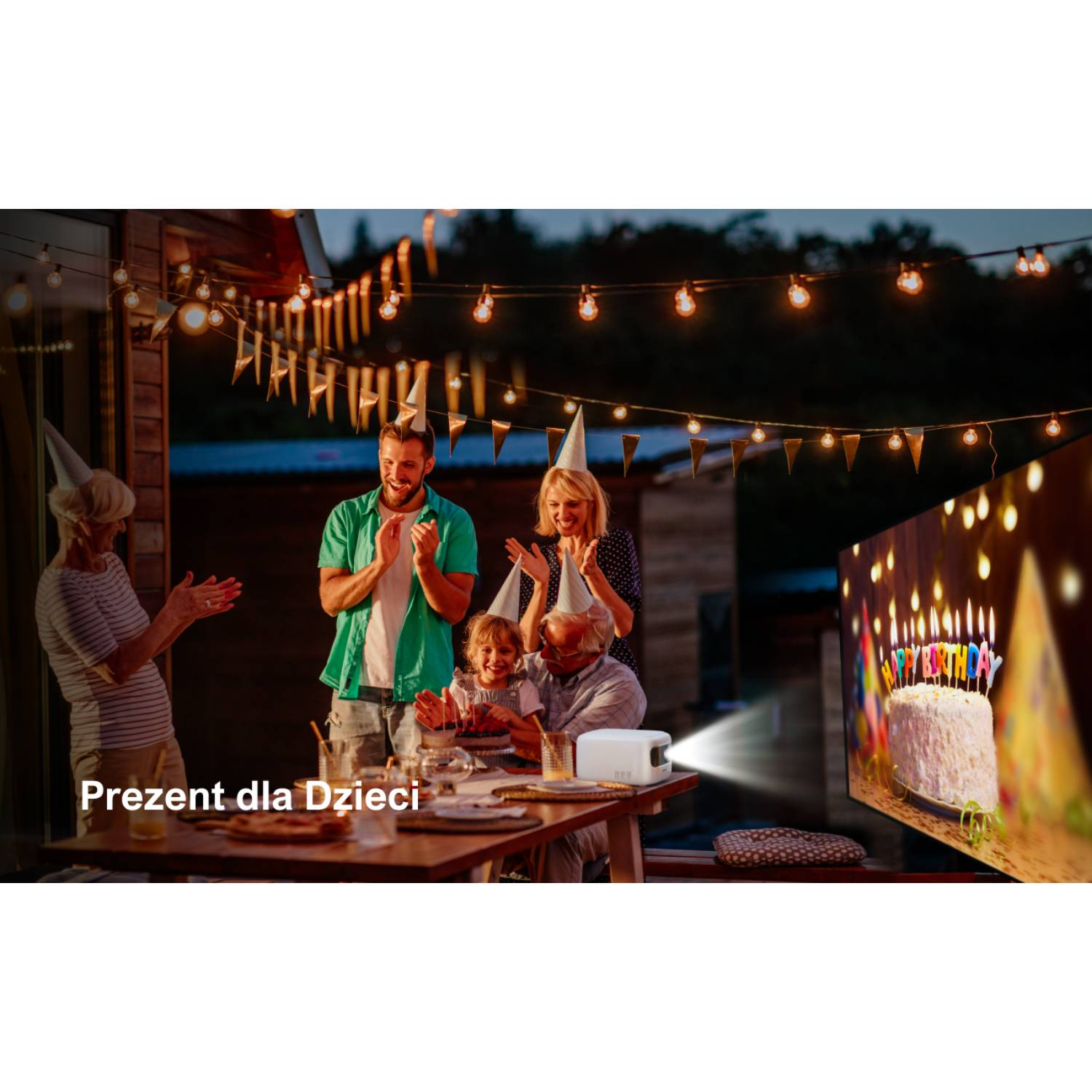 Rodzina świętuje urodziny na zewnątrz. Ludzie noszą czapki urodzinowe. Projektor wyświetla tort. Lampki dekorują tło.