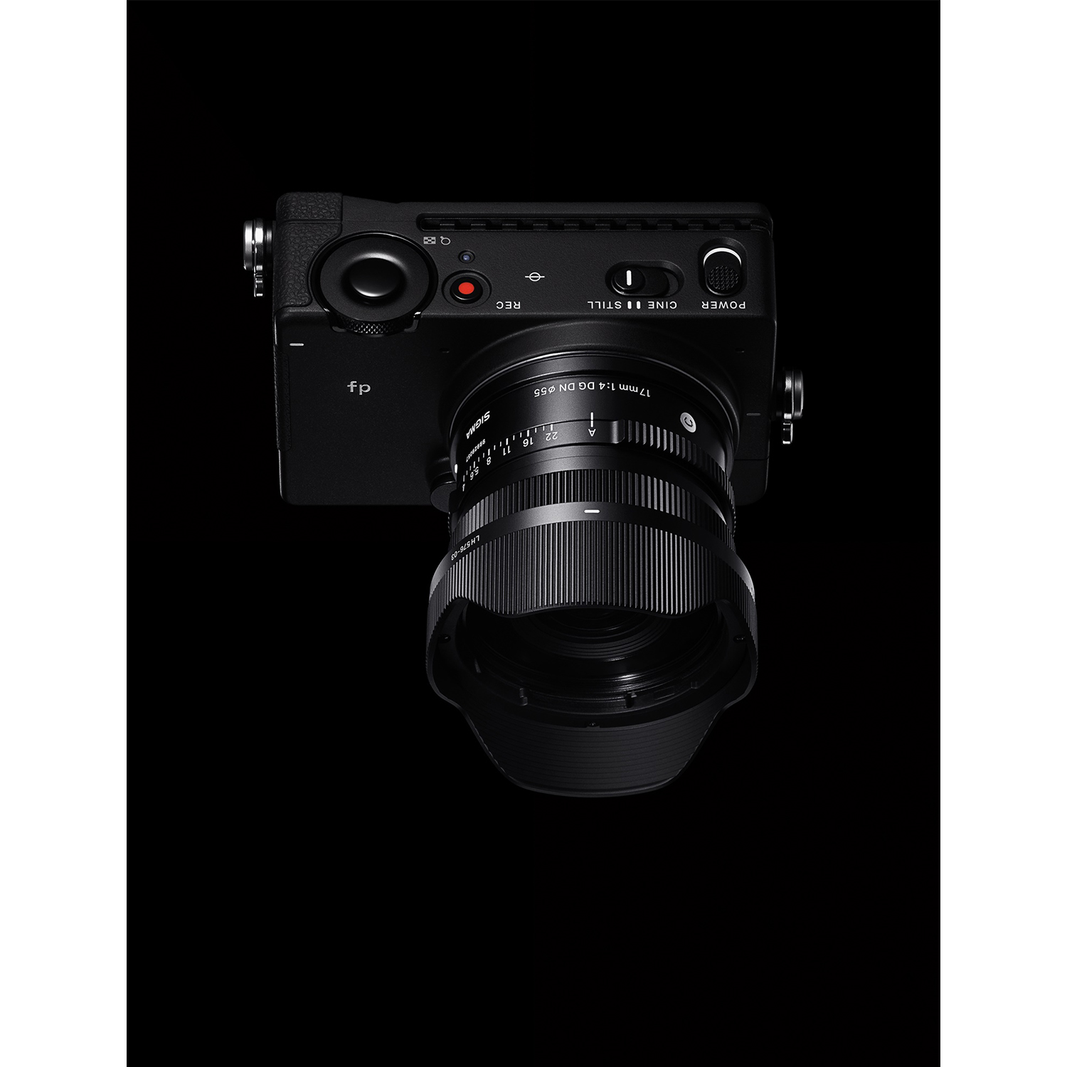 Una fotocamera Sigma fp nera con un obiettivo da 17 mm è mostrata su sfondo nero. L'obiettivo è a fuoco.