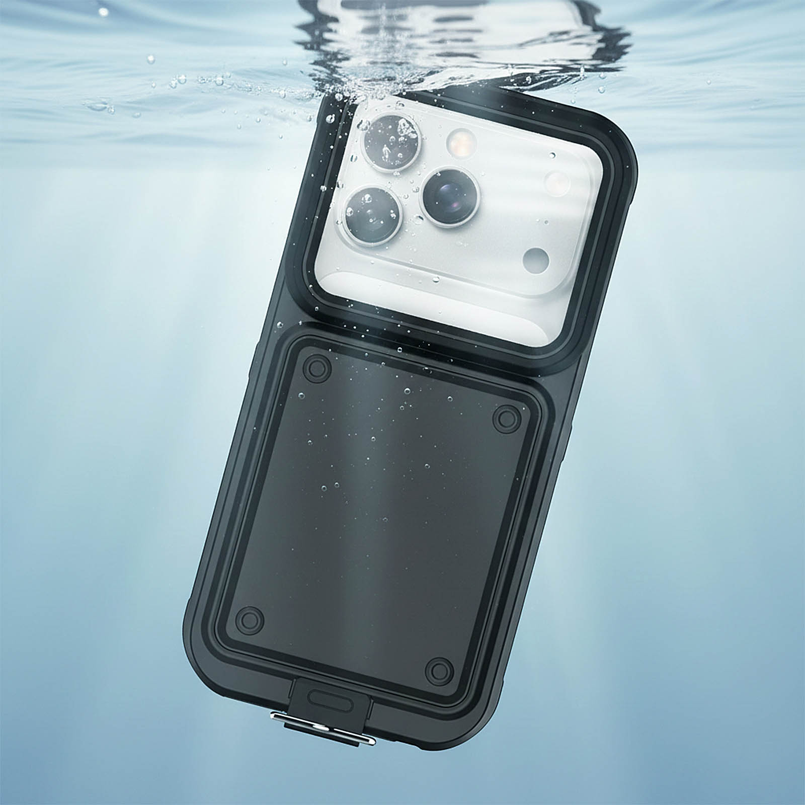 Eine wasserdichte Handyhülle unter Wasser. Sie ist schwarz, rechteckig mit abgerundeten Ecken. Blasen schweben darum.