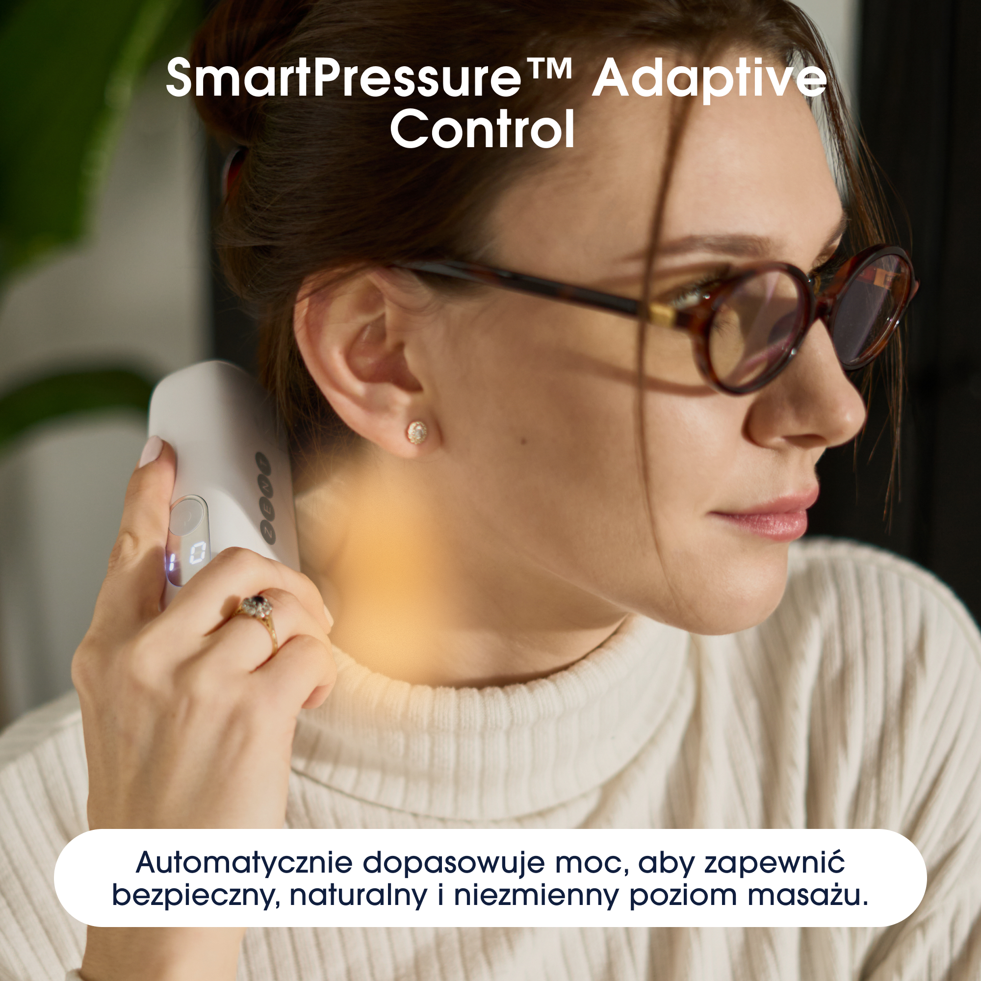 Kobieta używa masażera szyi. Nosi okulary i pierścionek. Urządzenie jest białe.
