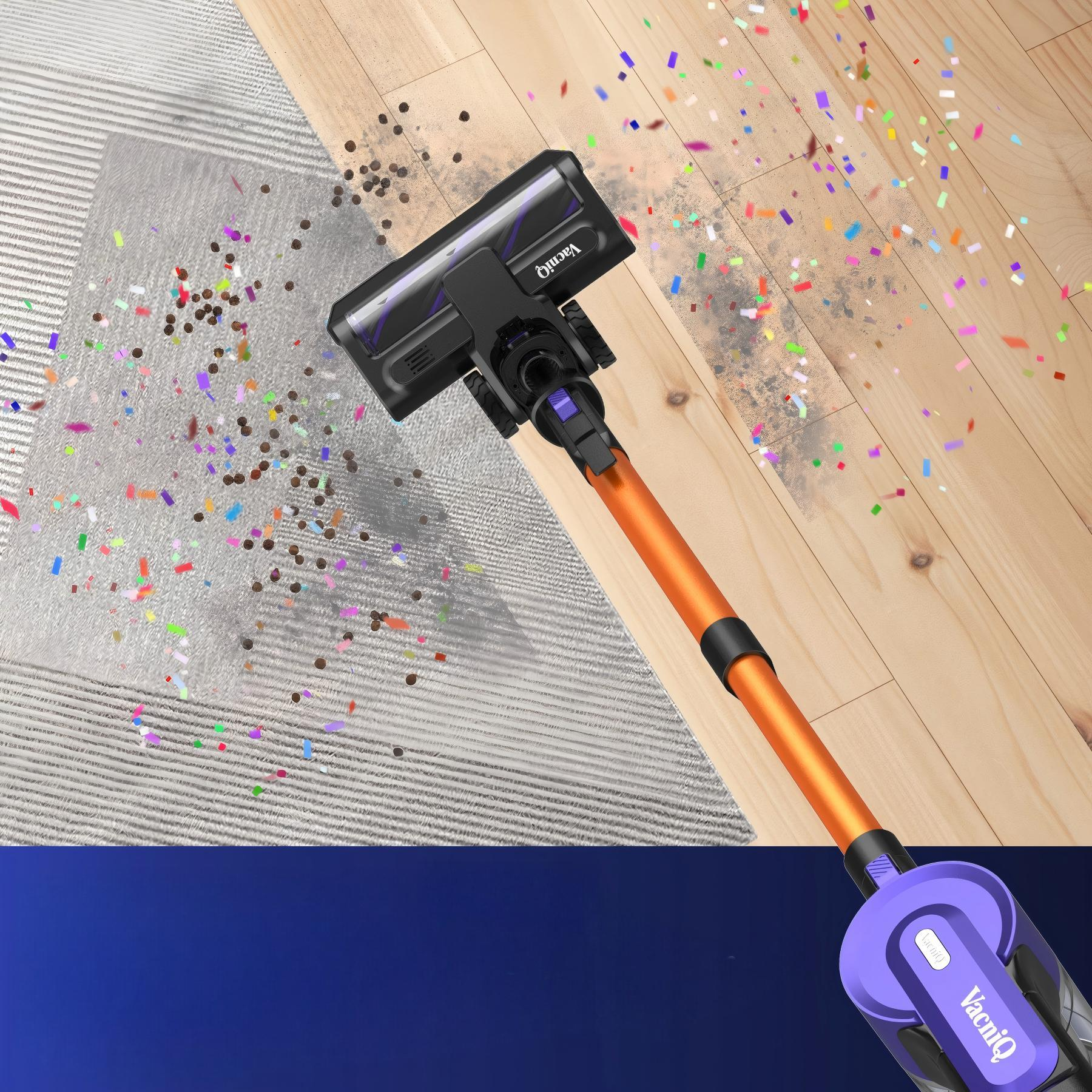 Pomarańczowy i czarny odkurzacz czyści dywan i drewnianą podłogę. Konfetti jest rozrzucone.