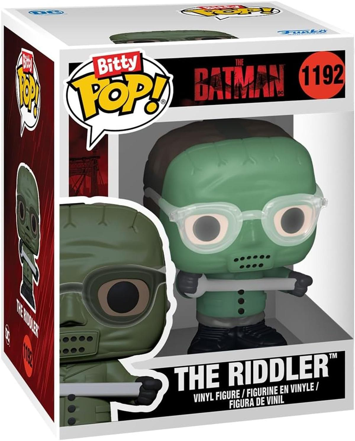 Una figura Funko Pop di Enigmista in una scatola. La figura è verde con occhiali e tiene una chiave inglese. La scatola ha loghi e testo.