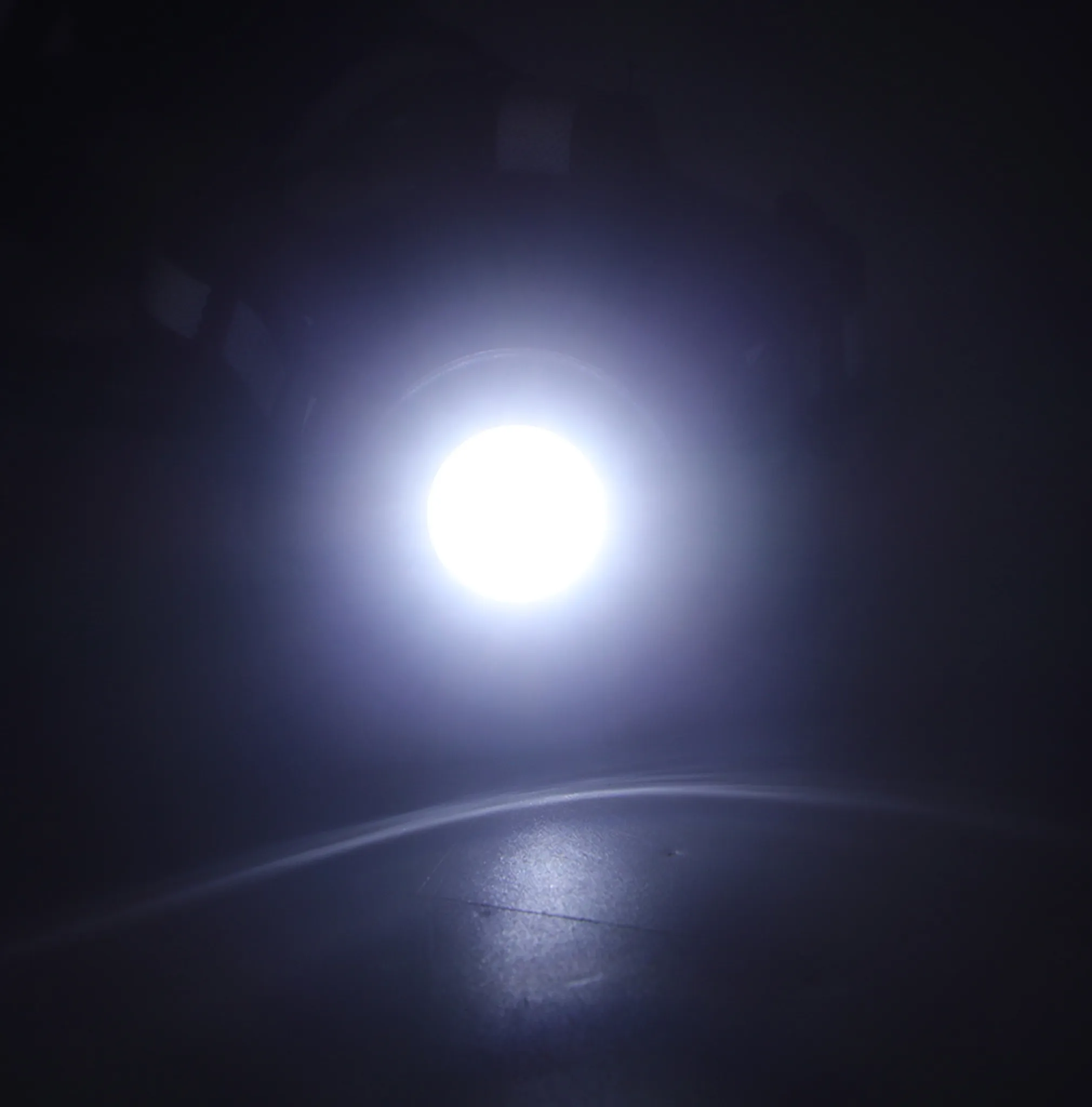 Ein heller Lichtkreis strahlt in dunkler Umgebung.