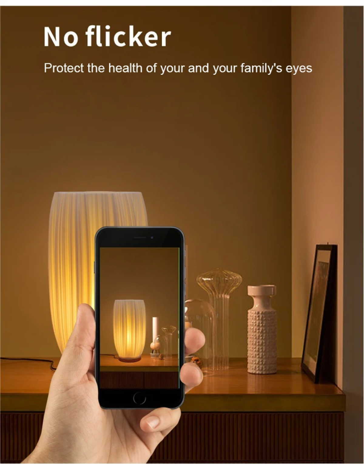 Hand hält ein Handy, das eine Lampe zeigt. Große Lampe dahinter.